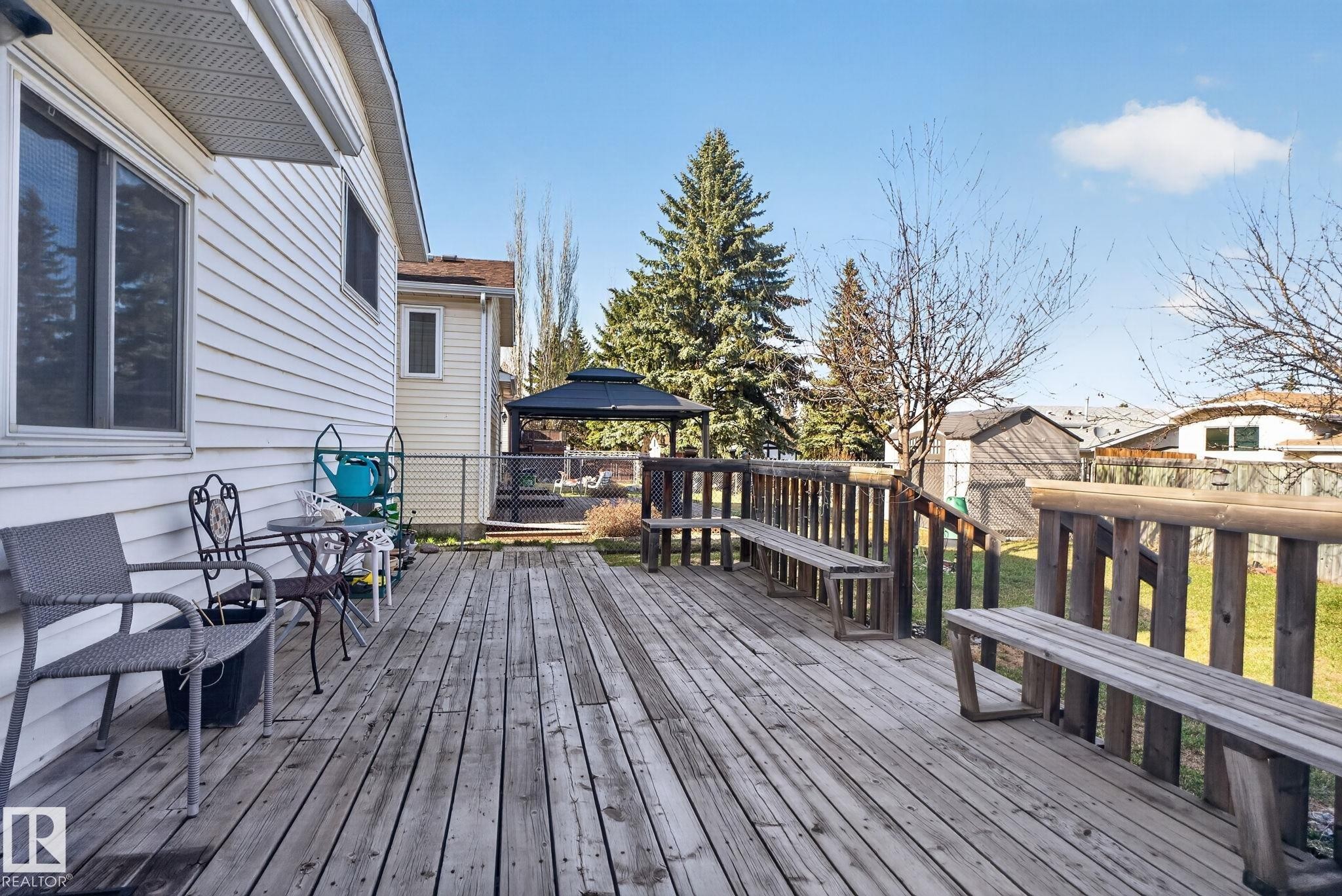 Expansive wooden deck featuring built-in benches and a sturdy wooden railing - 8403 190 Street, Edmonton, AB - Outdoor With Deck Patio Veranda With Exterior