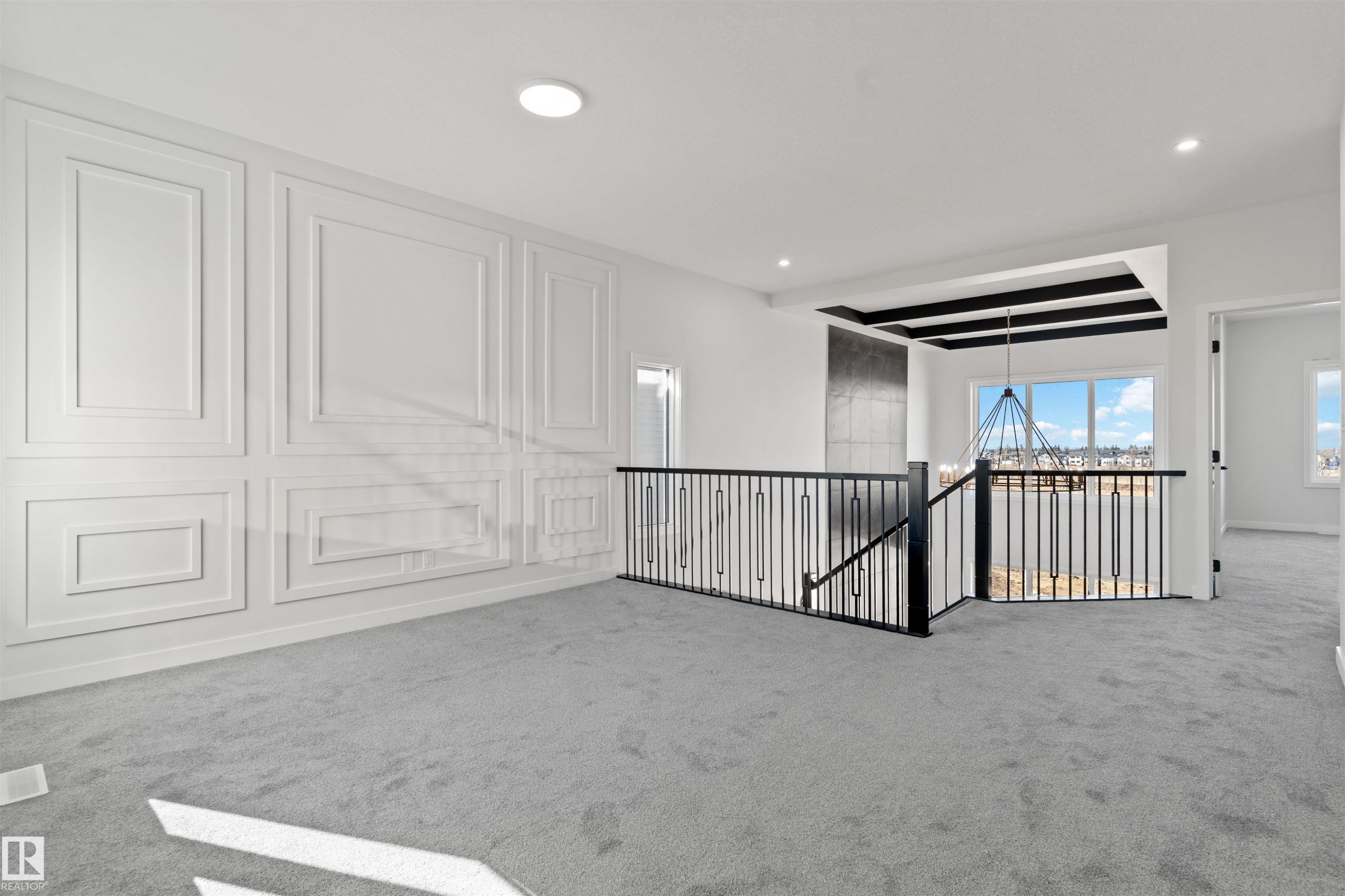 White paneled accent wall complemented by light grey carpeting - 1849 Crossbill Loop Nw, Edmonton, AB - Indoor Photo Showing Other Room