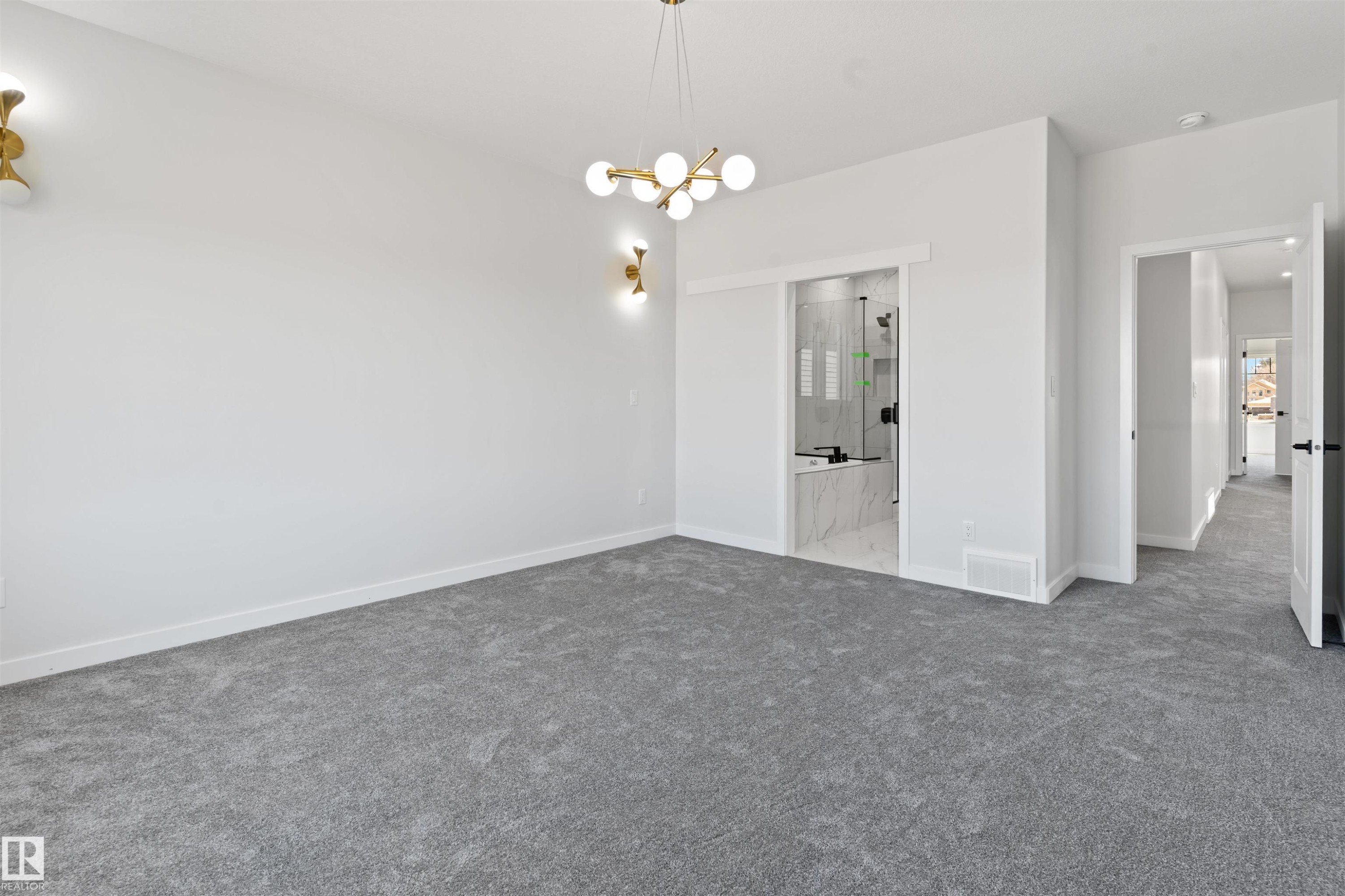 Spacious room with plush gray carpeting, contemporary brass chandelier, and two coordinating brass sconces - 1849 Crossbill Loop Nw, Edmonton, AB - Indoor Photo Showing Other Room