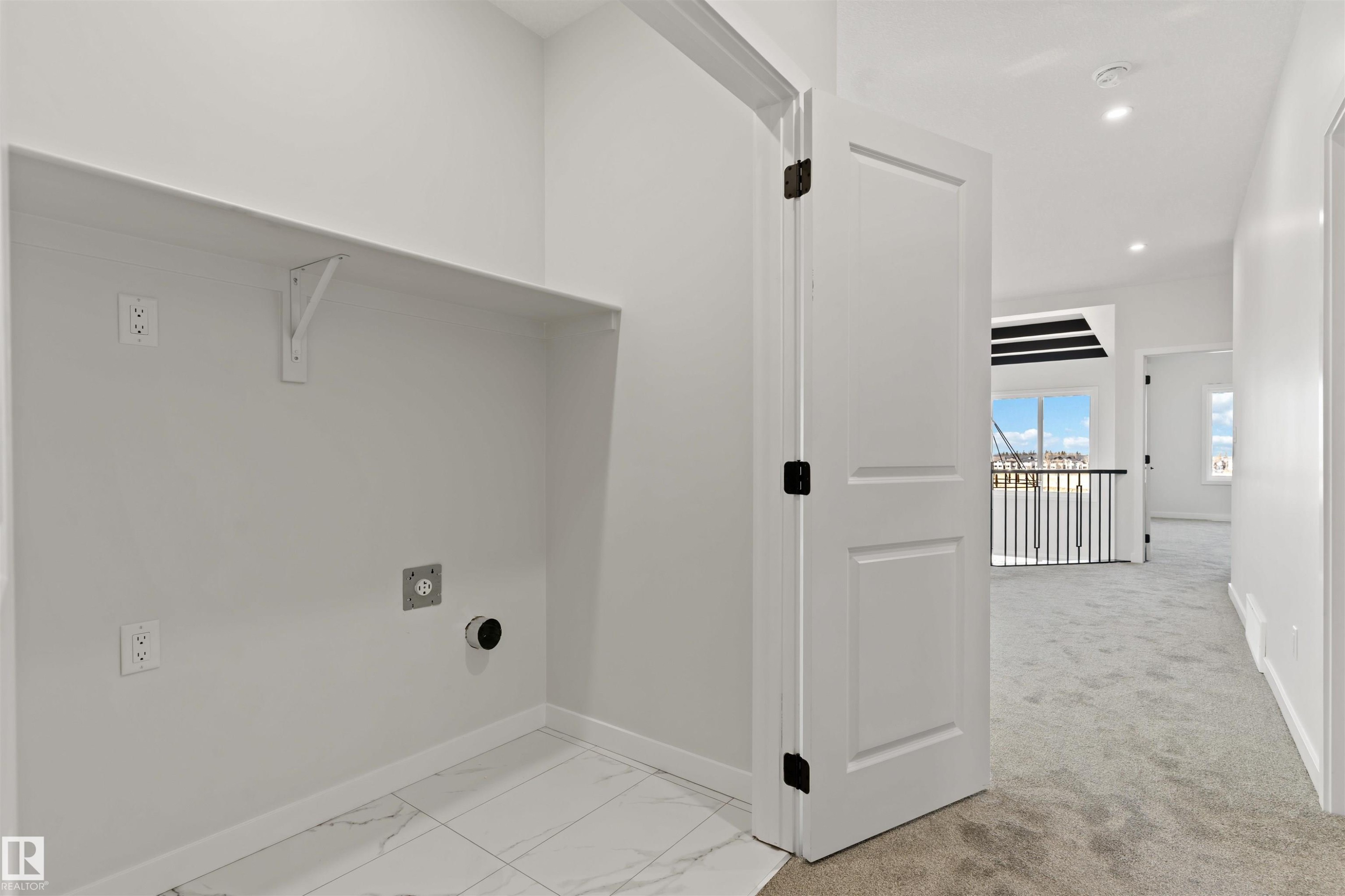 Dedicated laundry alcove with a built-in shelf, modern white tile flooring, and essential utility hookups - 1849 Crossbill Loop Nw, Edmonton, AB - Indoor Photo Showing Other Room