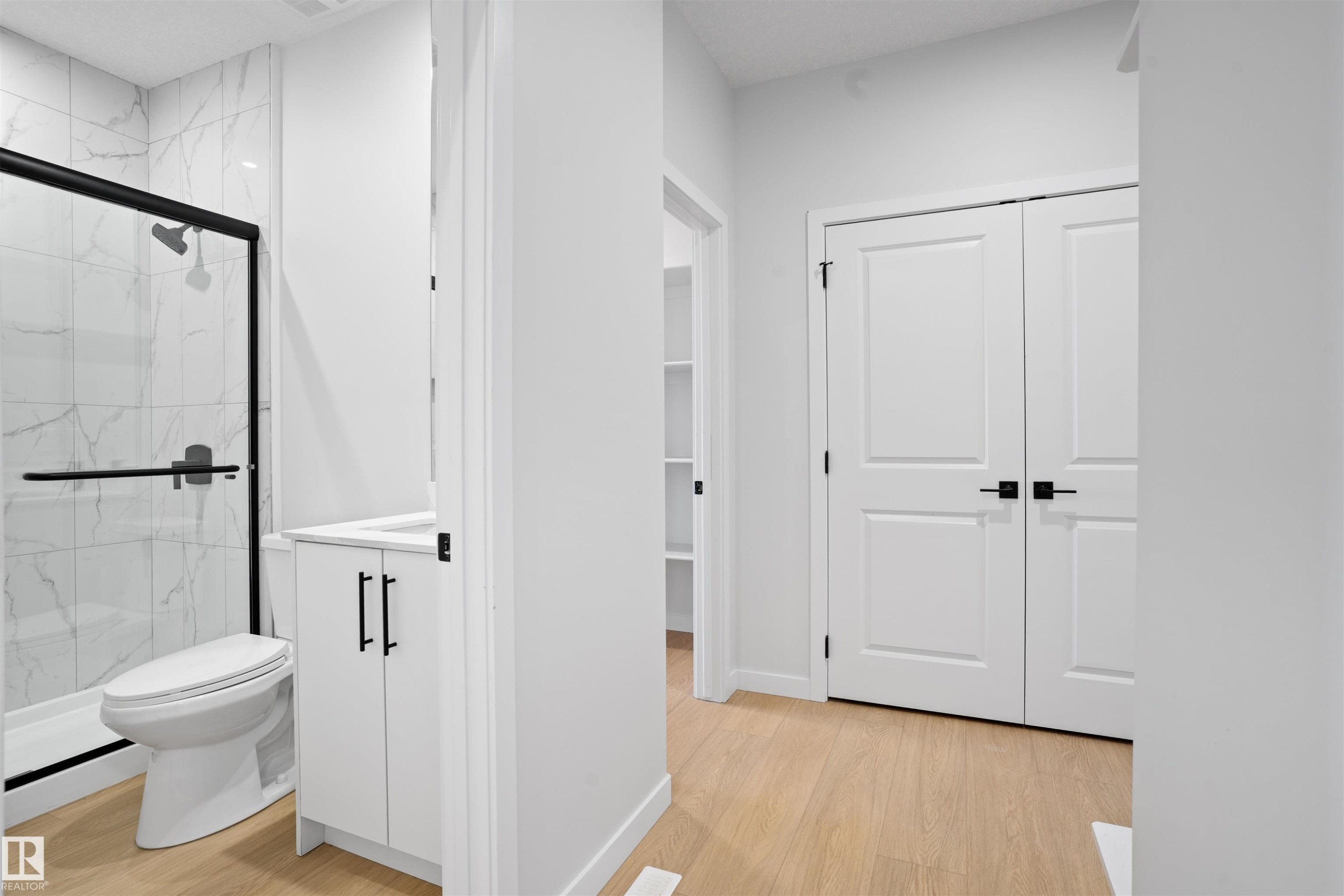 Bathroom featuring a walk-in shower with clear glass enclosure and black trim - 1849 Crossbill Loop Nw, Edmonton, AB - Indoor