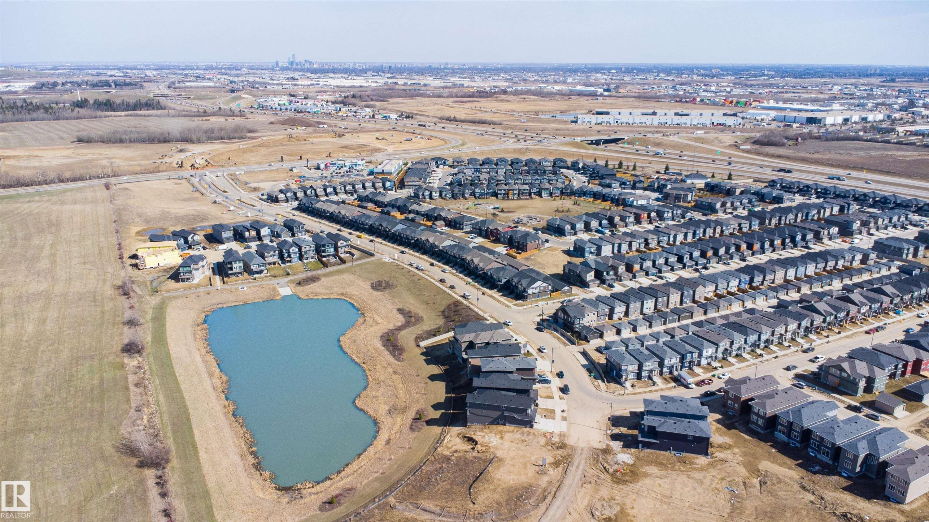 Expansive aerial perspective showcasing a residential development with a large central pond - 1849 Crossbill Loop Nw, Edmonton, AB - Outdoor With View