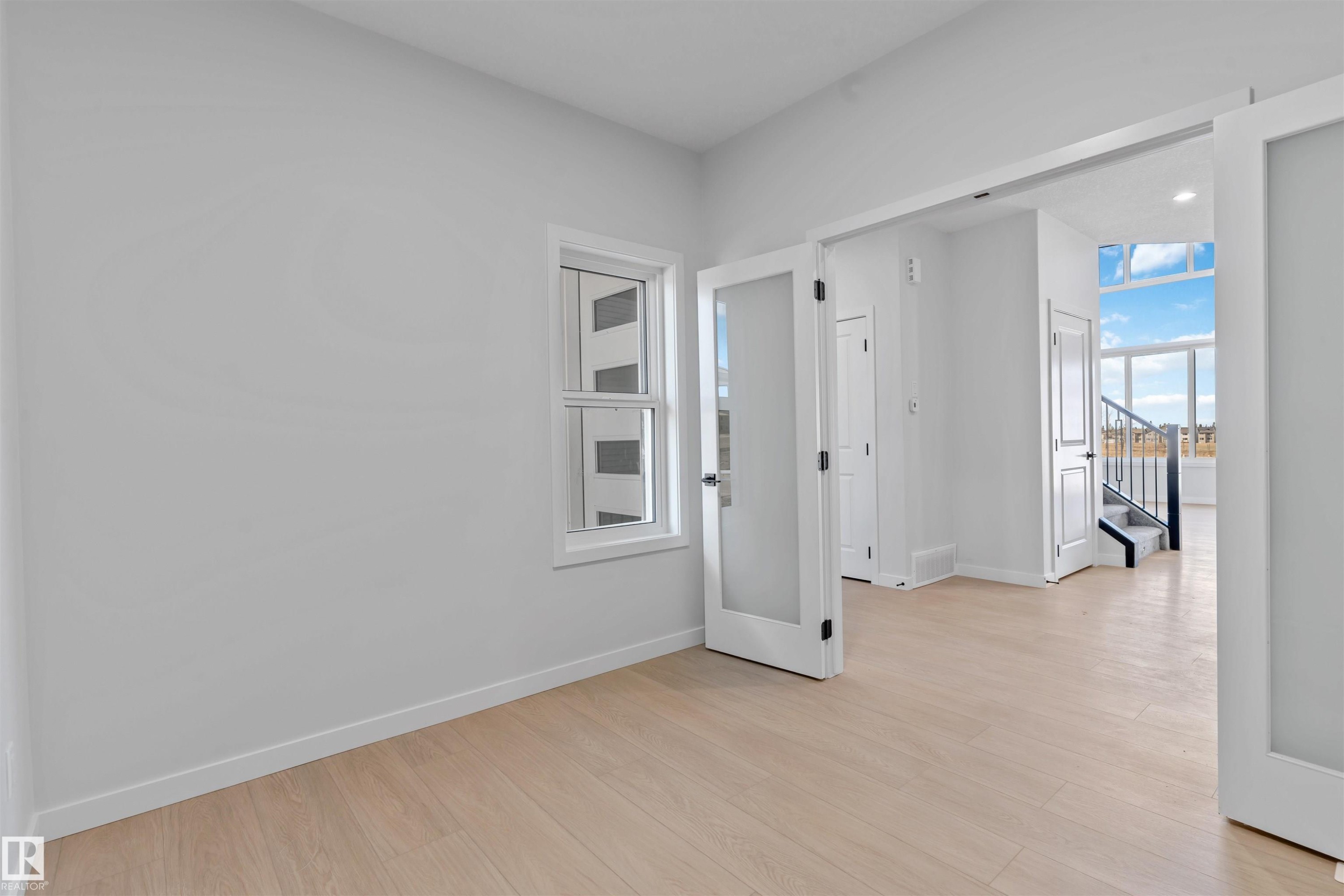 Bright interior space featuring light wood-finish flooring - 1849 Crossbill Loop Nw, Edmonton, AB - Indoor Photo Showing Other Room