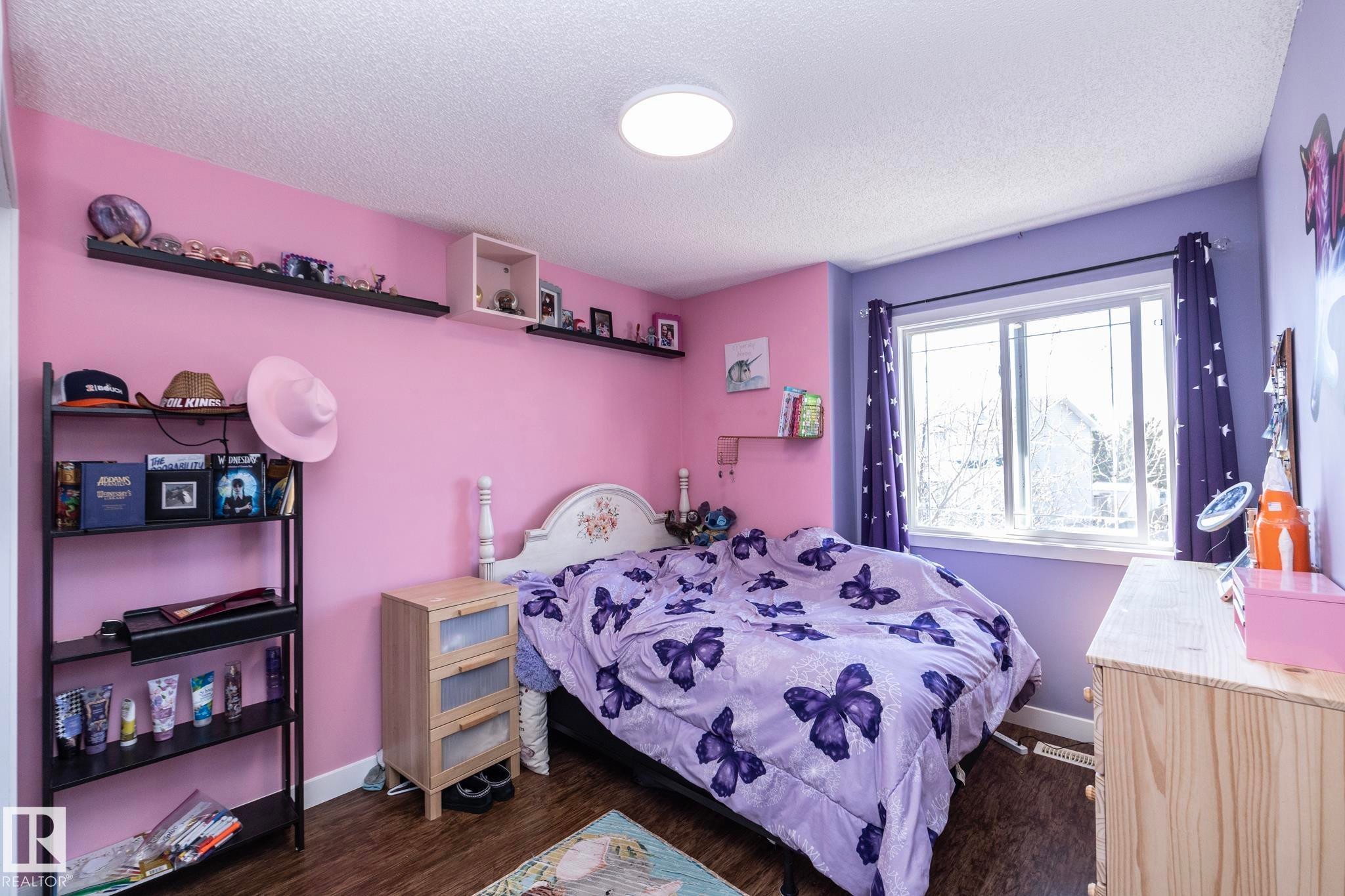 Bedroom featuring dual-tone painted walls and wood-finish flooring - 65 Birchmont Drive, Leduc, AB - Indoor Photo Showing Bedroom