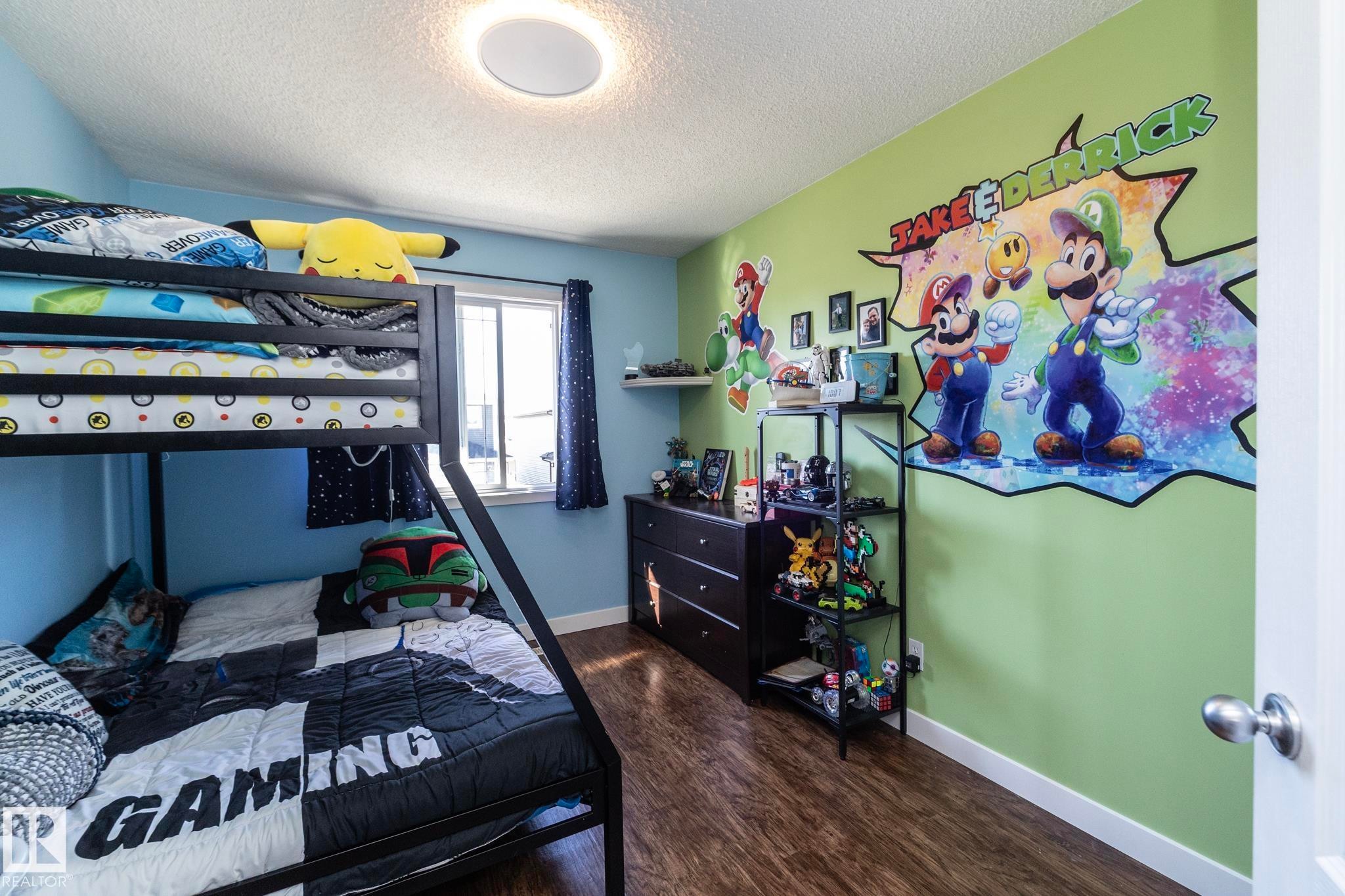 Bedroom featuring a metal bunk bed and wood-finish flooring - 65 Birchmont Drive, Leduc, AB - Indoor Photo Showing Bedroom