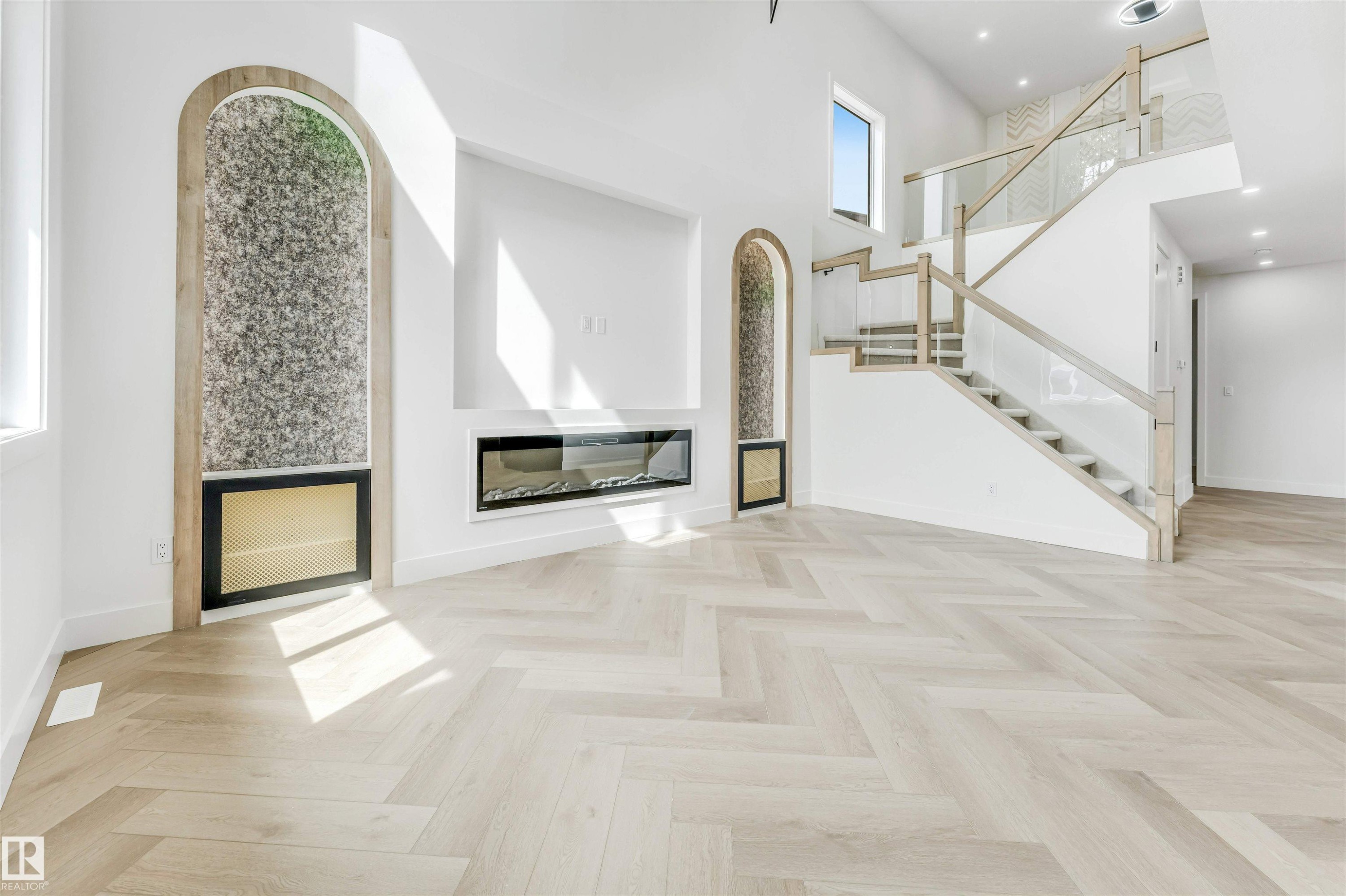 Spacious open-concept living area featuring light wood-finish flooring in a herringbone pattern - 4006 35 St, Beaumont, AB - Indoor Photo Showing Other Room With Fireplace