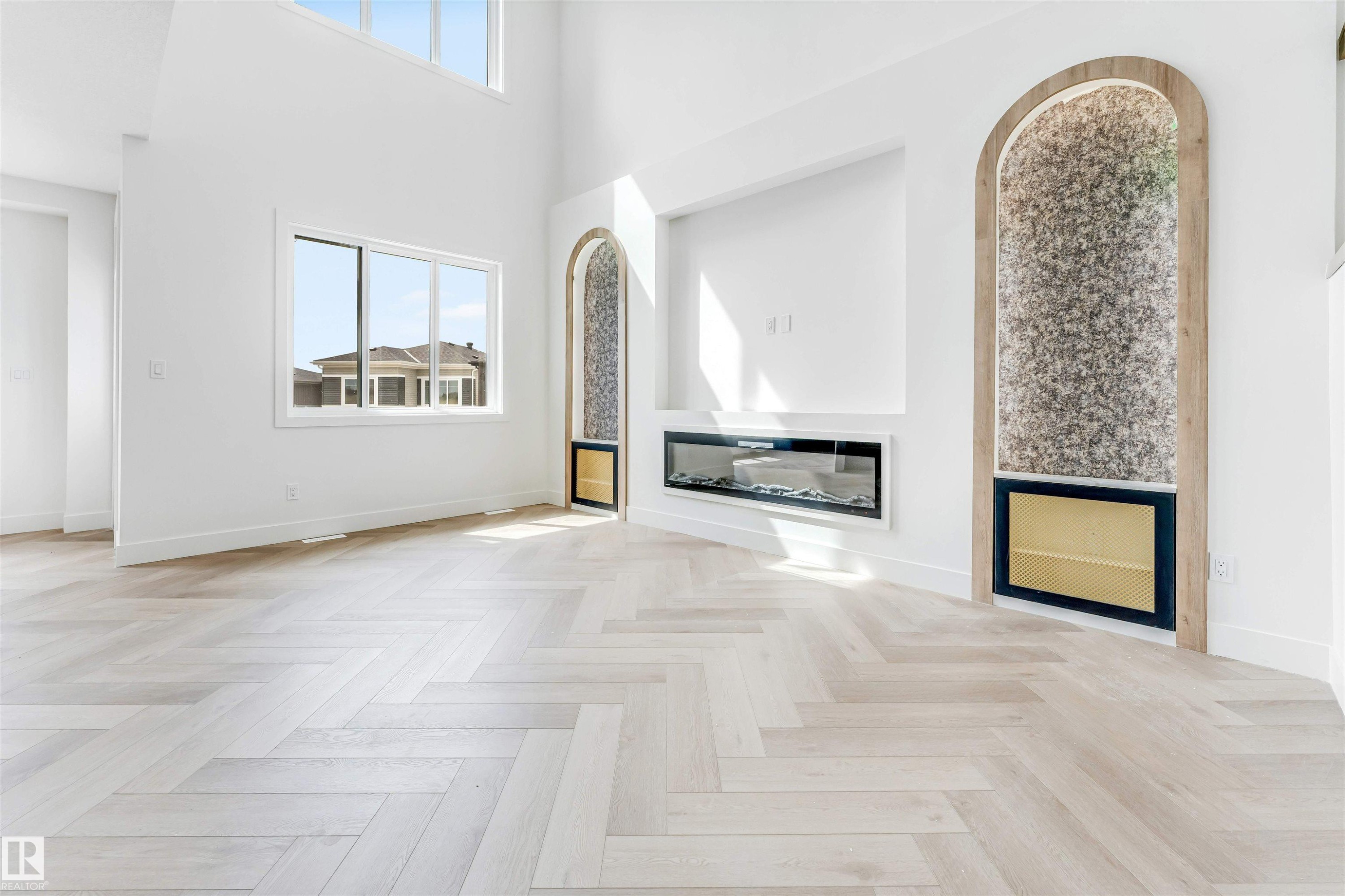 Herringbone wood-finish flooring complements the bright, open interior - 4006 35 St, Beaumont, AB - Indoor Photo Showing Other Room With Fireplace