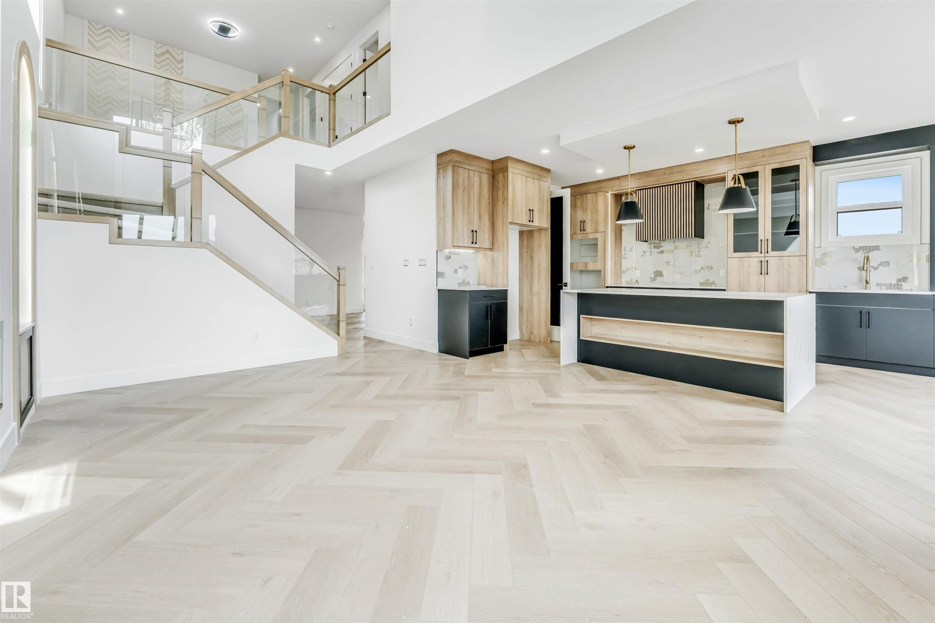 Spacious open-concept interior featuring light wood-finish herringbone flooring - 4006 35 St, Beaumont, AB - Indoor Photo Showing Other Room