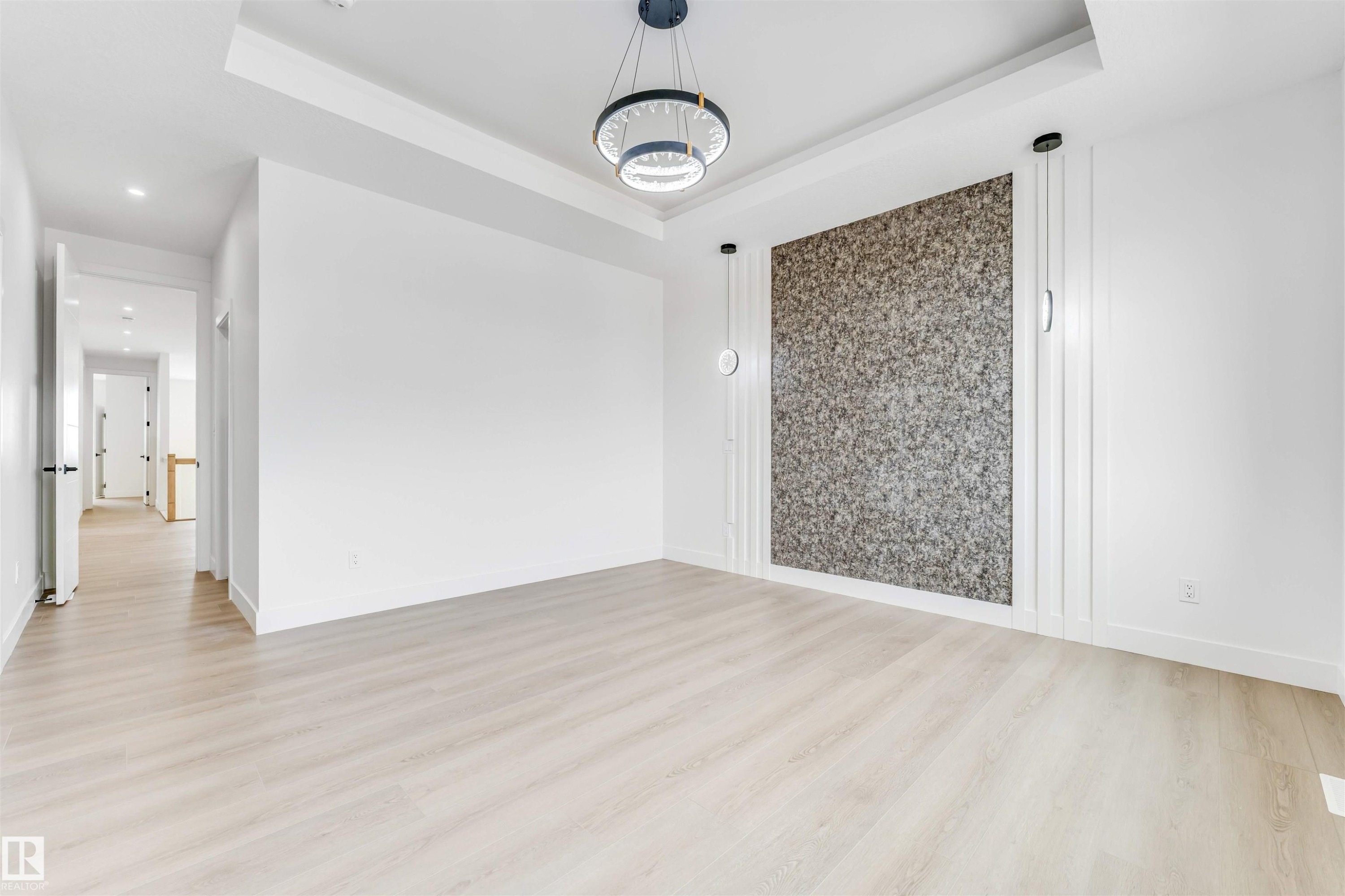 Spacious room featuring light wood-finish flooring and a tray ceiling - 4006 35 St, Beaumont, AB - Indoor Photo Showing Other Room