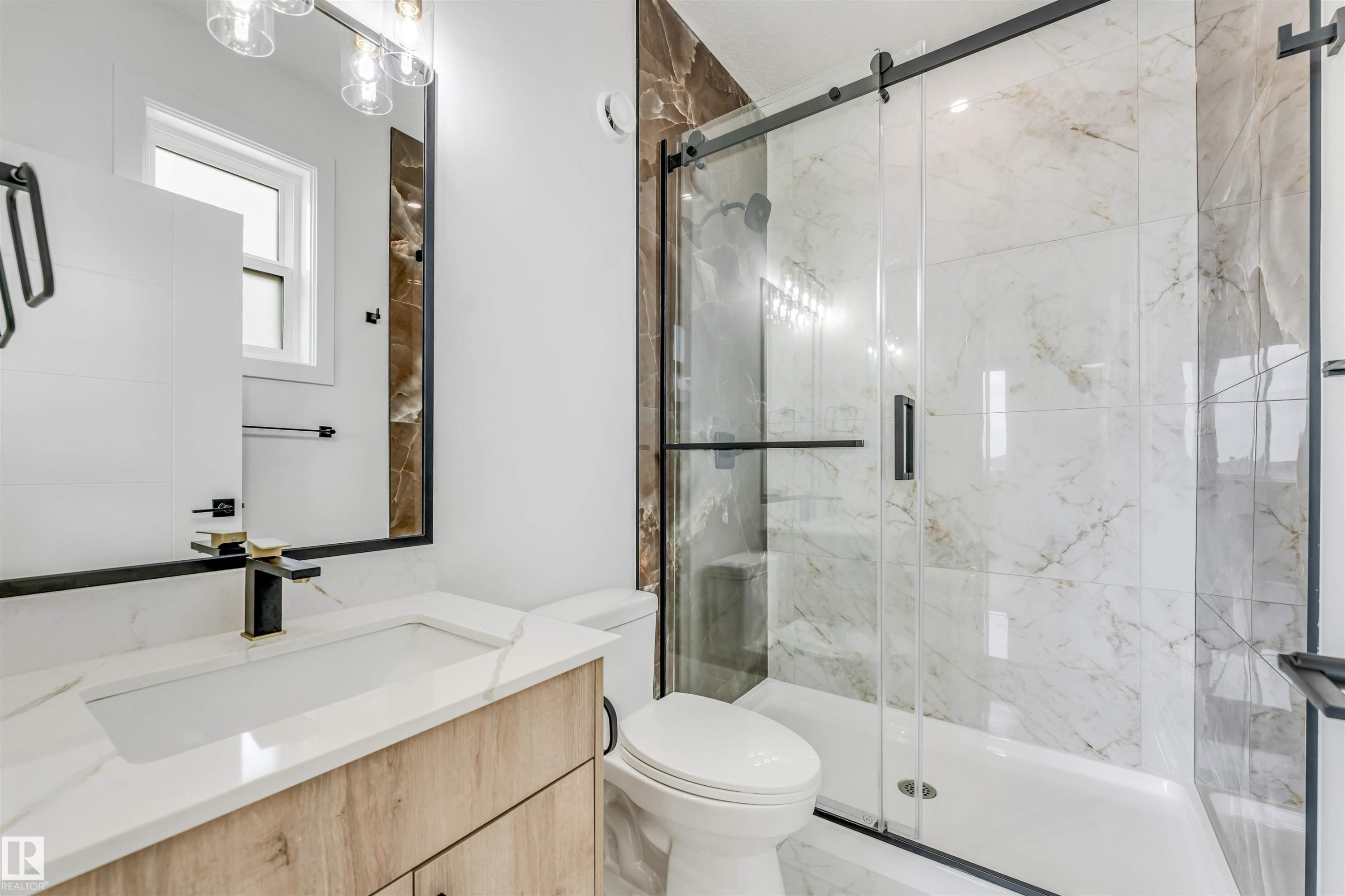 Bathroom featuring a glass-enclosed shower with a sliding door, white marble-look wall tiles, and a natural wood-finish vanity with a white countertop - 4006 35 St, Beaumont, AB - Indoor Photo Showing Bathroom