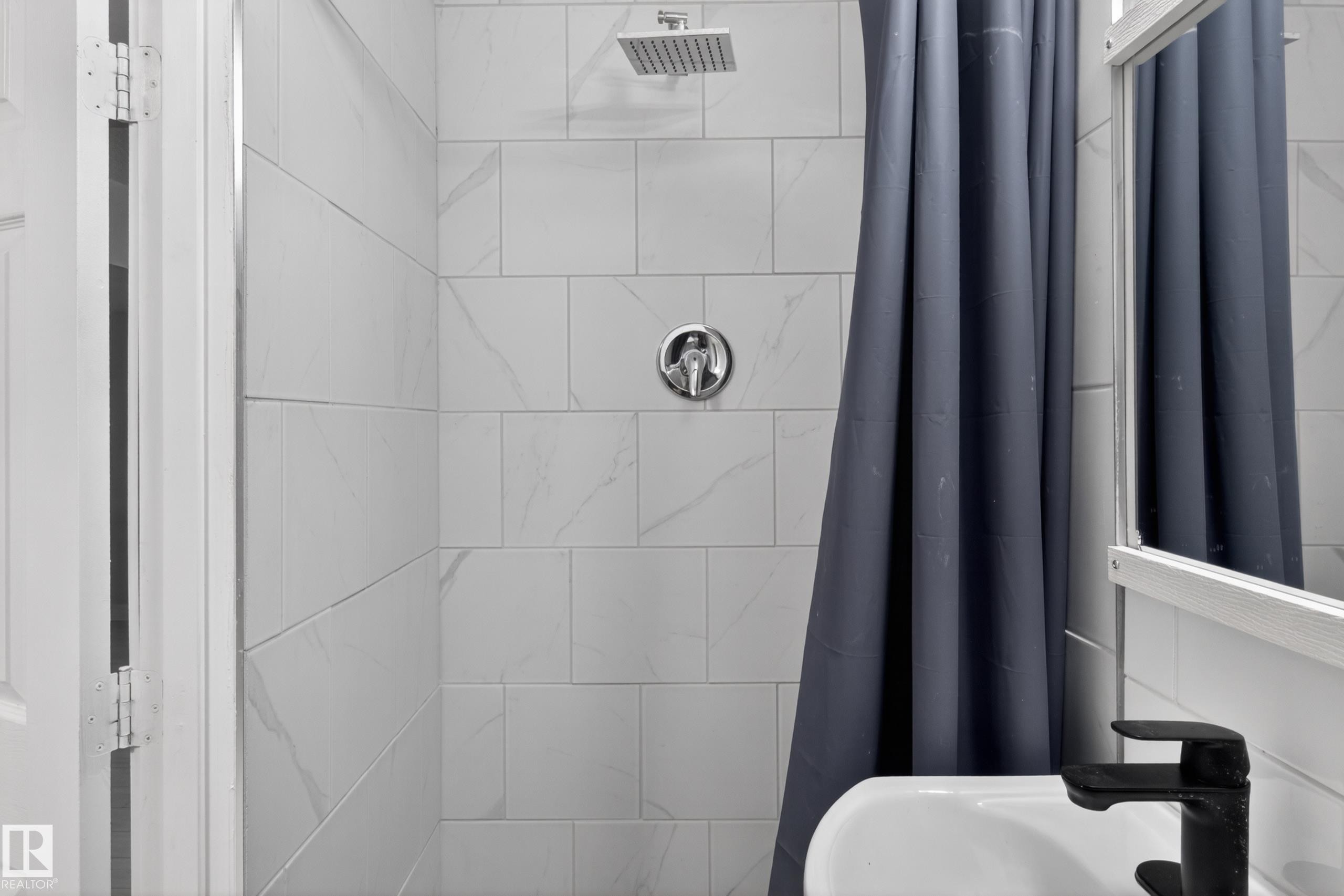 Shower with white subway tile surround, chrome fixtures, and a ceiling-mounted rainfall showerhead - 8722 112 Avenue, Edmonton, AB - Indoor Photo Showing Bathroom