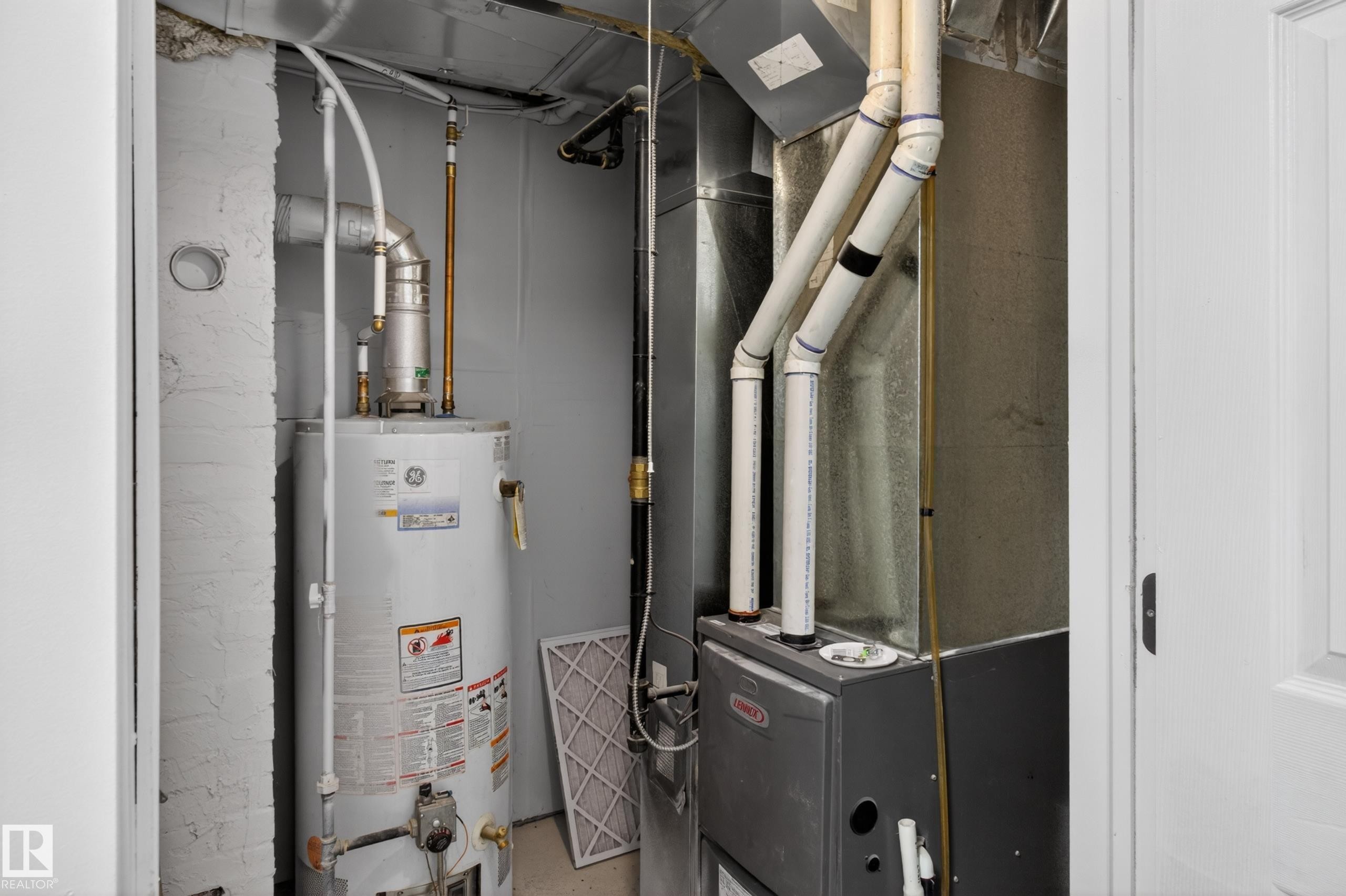 Dedicated utility closet housing the water heater and HVAC system - 8722 112 Avenue, Edmonton, AB - Indoor Photo Showing Basement