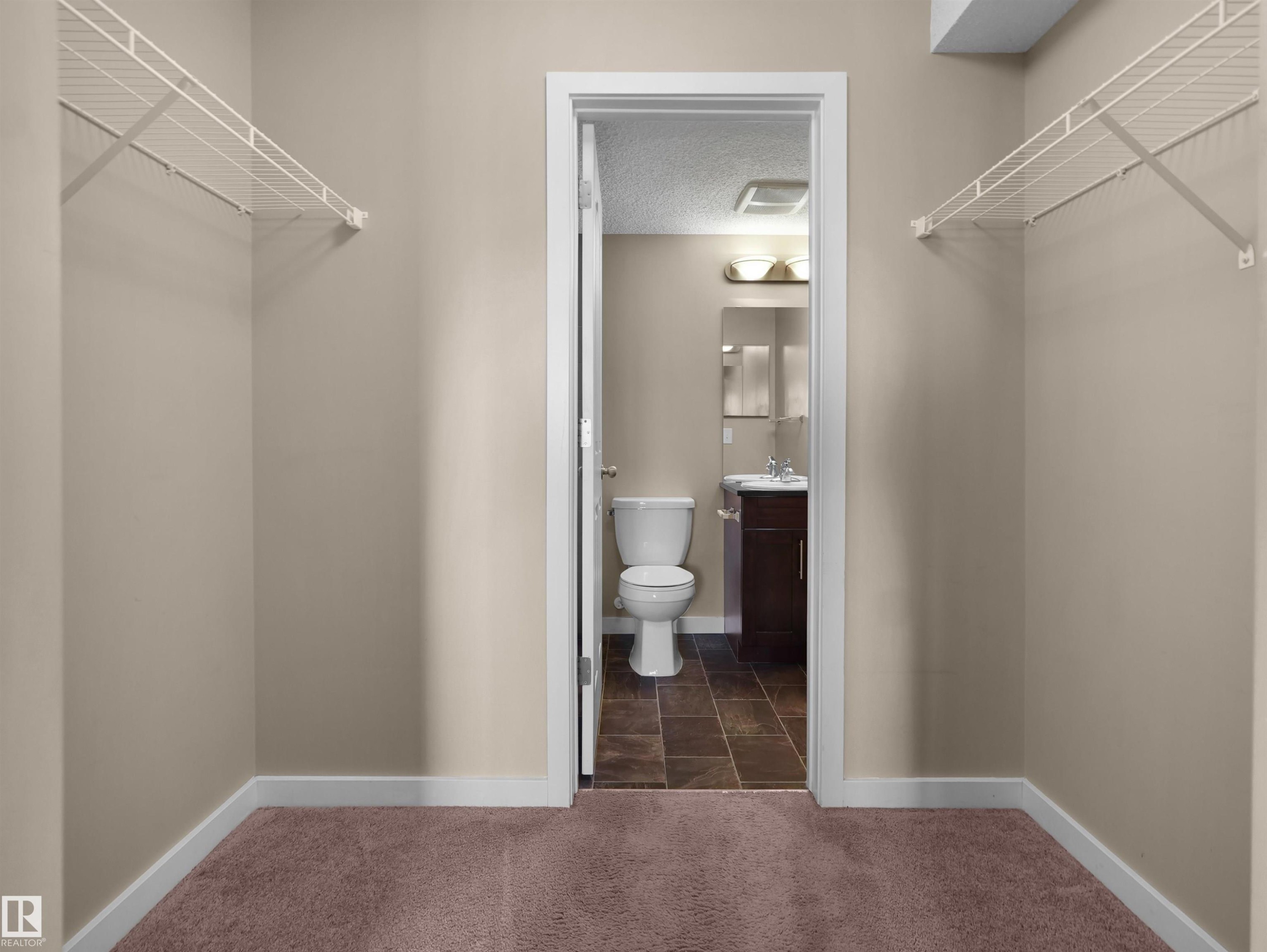 Walk-in closet with wire shelving and plush carpeting - 417 1060 Mcconachie Boulevard, Edmonton, AB - Indoor Photo Showing Bathroom