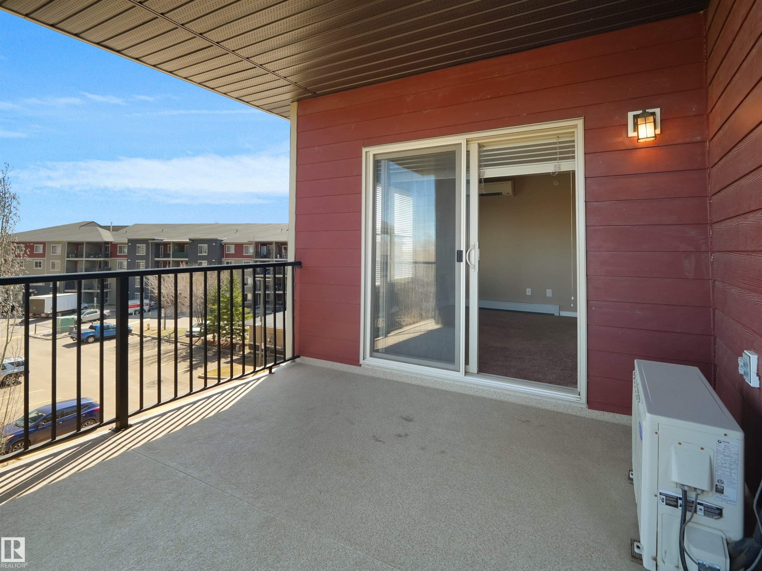Private balcony featuring a concrete floor, black metal railing, and direct access to interior living space via a sliding glass door - 417 1060 Mcconachie Boulevard, Edmonton, AB - Outdoor With Balcony With Exterior