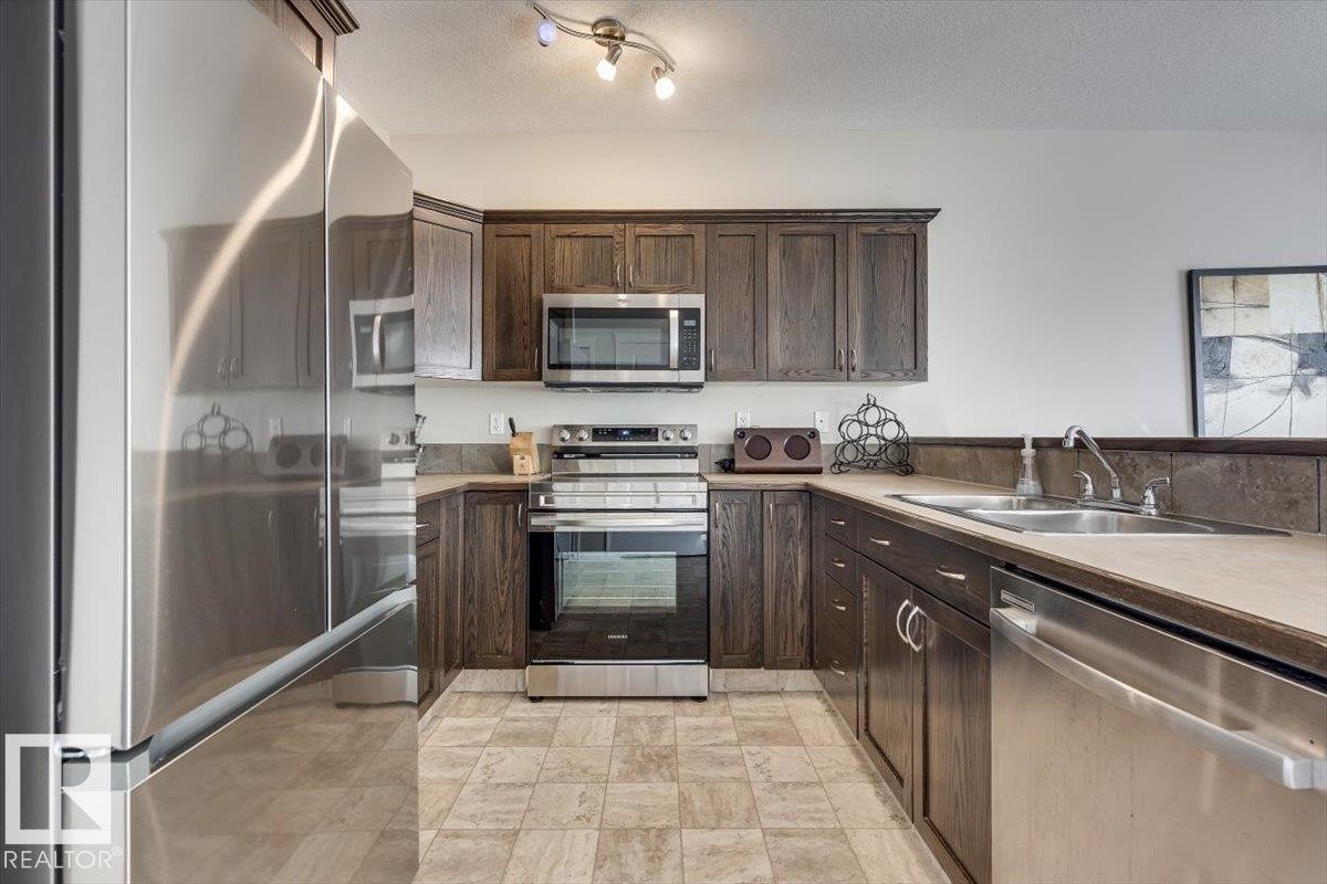 #111 50 Lucky Pl, Sylvan Lake, AB - Indoor Photo Showing Kitchen With Stainless Steel Kitchen With Double Sink