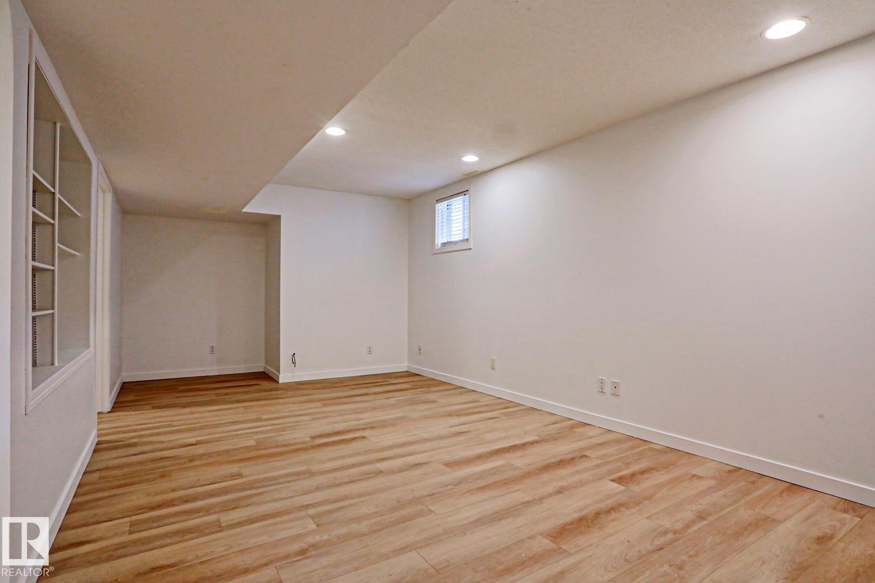 Spacious room featuring wood-finish flooring, recessed lighting, and built-in shelving - 9611 81 Avenue, Edmonton, AB - Indoor Photo Showing Other Room