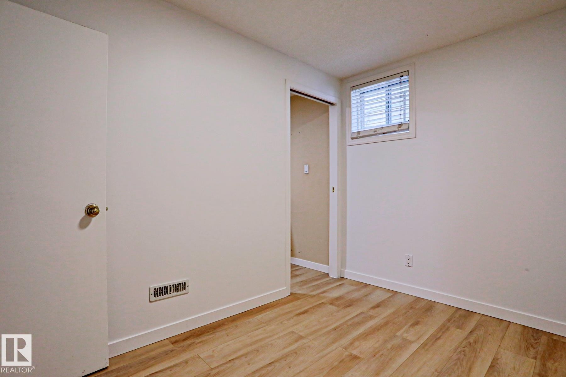 Room featuring wood-finish flooring, white walls, and a window with blinds - 9611 81 Avenue, Edmonton, AB - Indoor Photo Showing Other Room