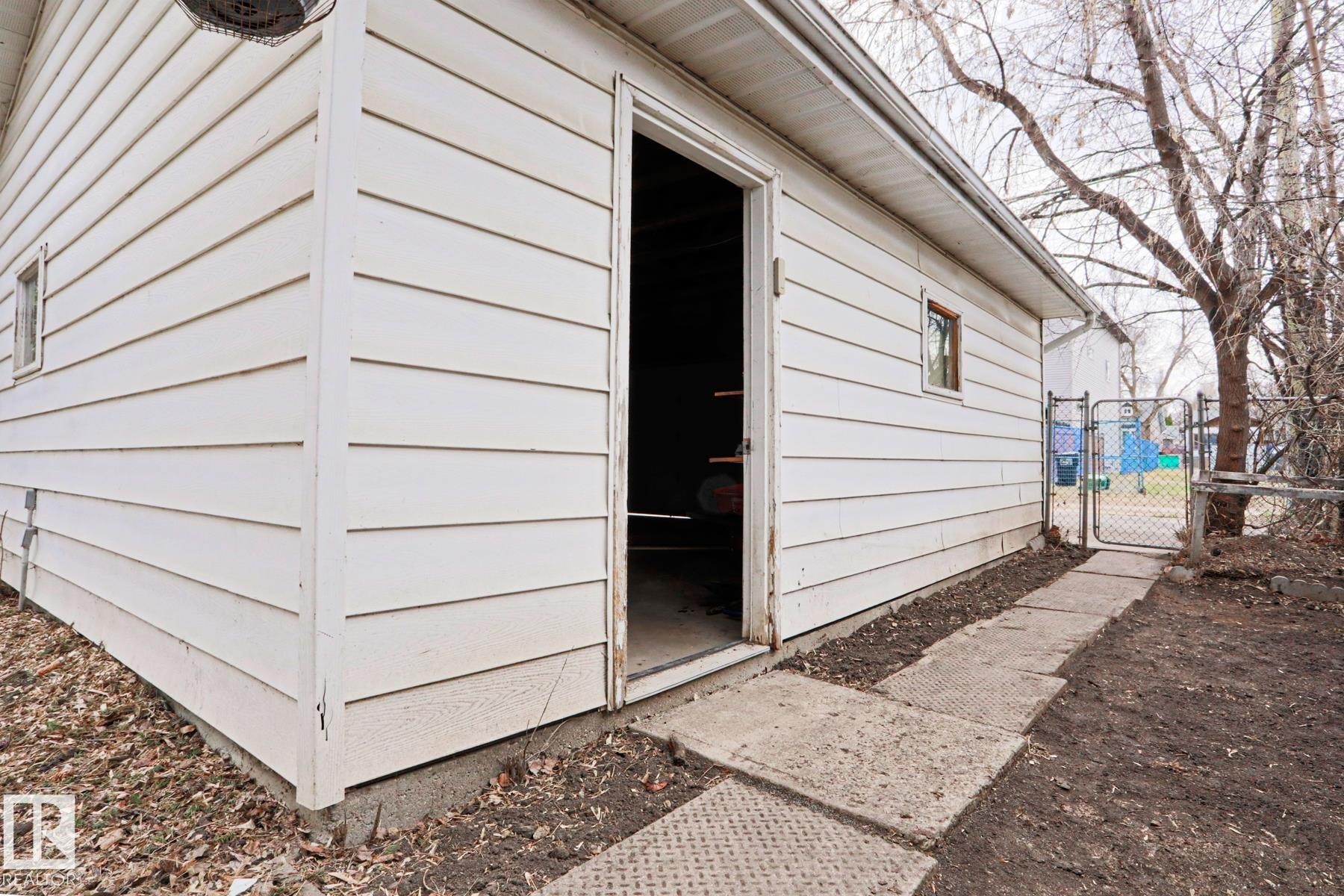 Detached outbuilding with white horizontal siding and a window - 9611 81 Avenue, Edmonton, AB - Outdoor With Exterior