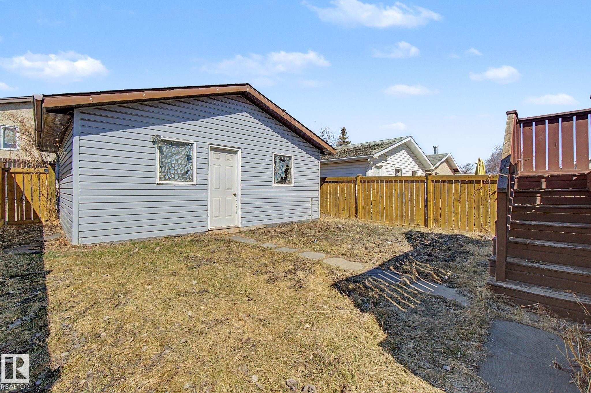 Detached outbuilding with light blue horizontal siding, a brown trim roofline, and a white entry door - 4106 38 Street, Edmonton, AB - Outdoor With Exterior