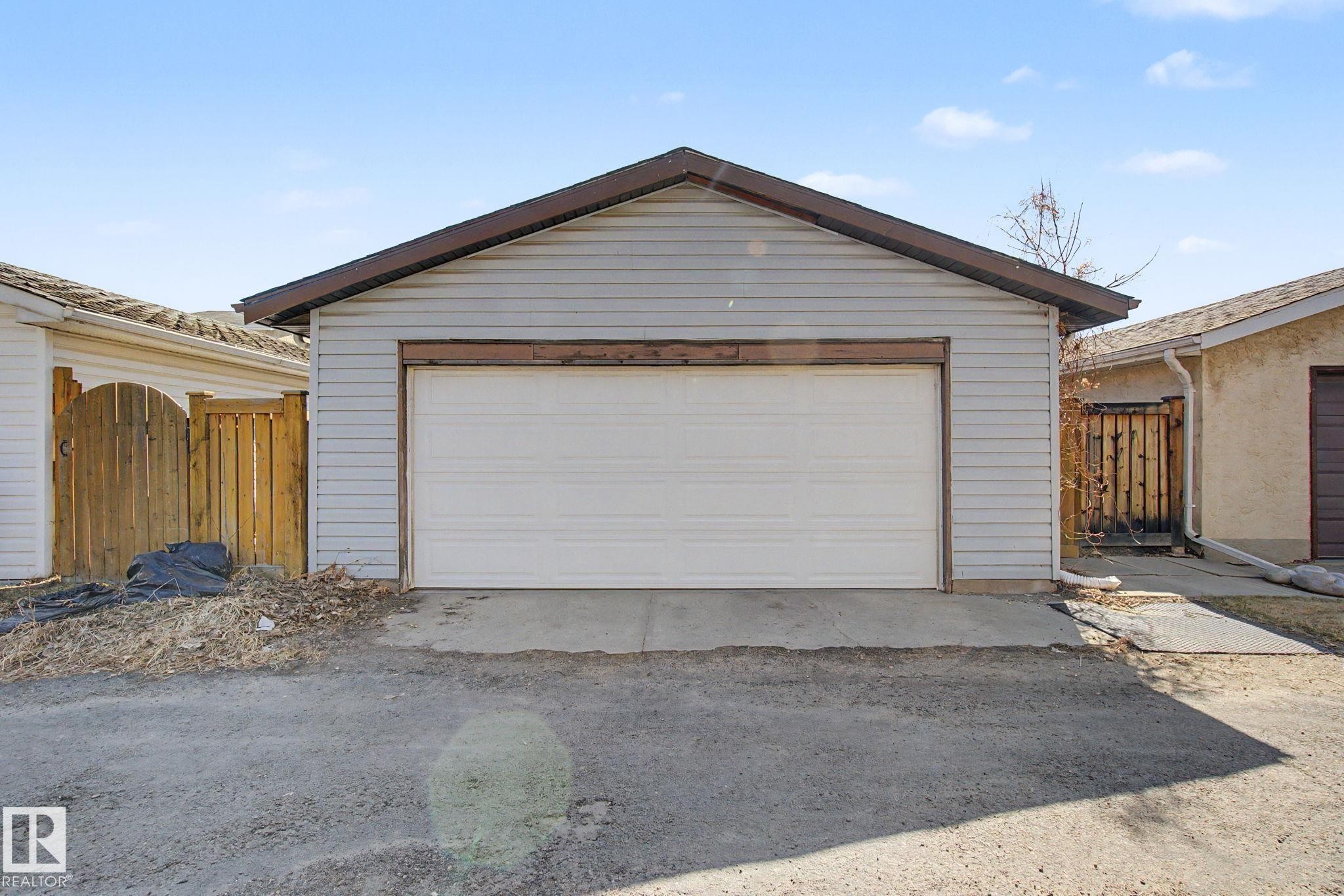 Detached garage with horizontal siding, a pitched roof, and a single roll-up garage door - 4106 38 Street, Edmonton, AB - Outdoor With Exterior