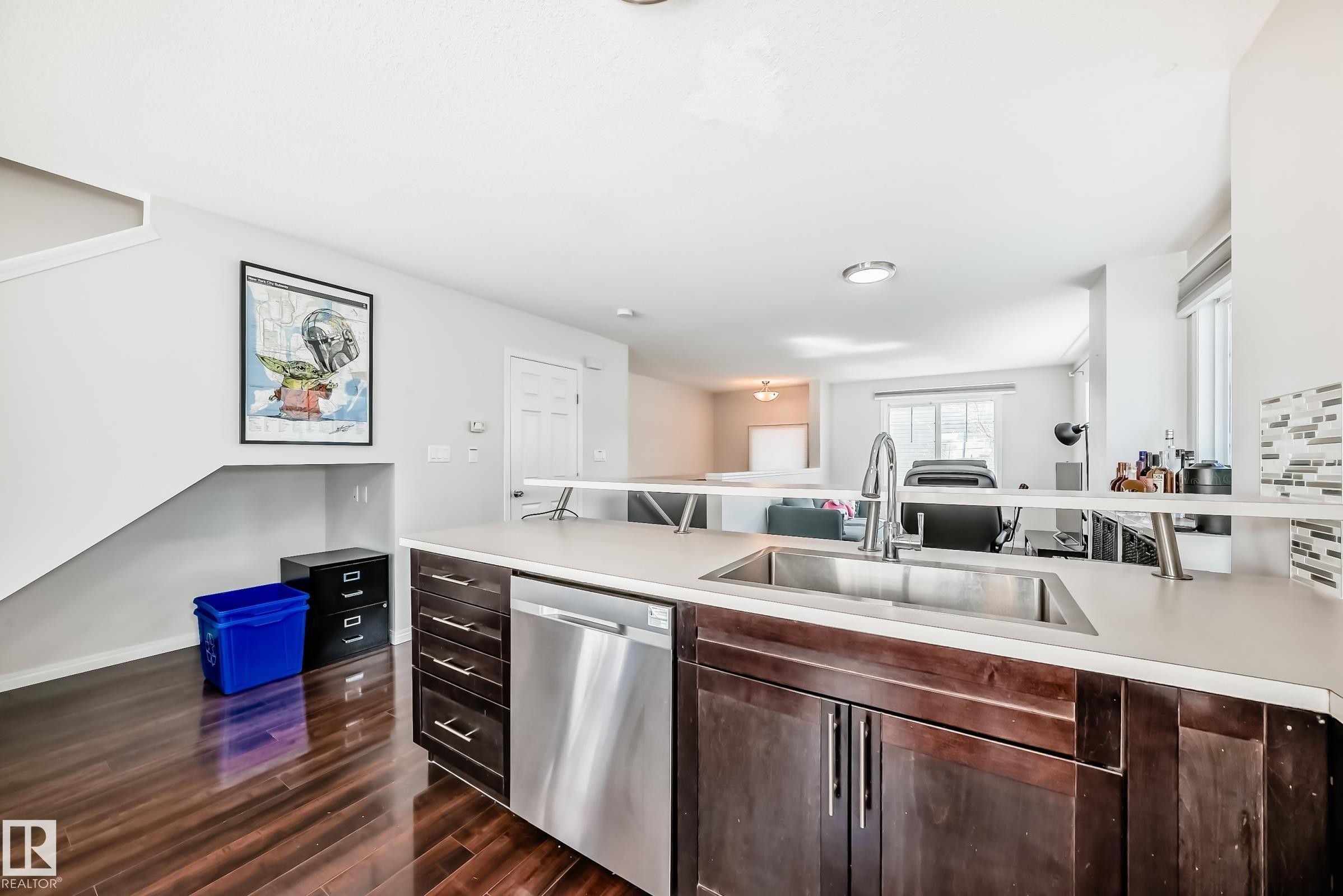 Kitchen island with integrated stainless steel sink and modern faucet - 45 4850 Terwillegar Common, Edmonton, AB - Indoor Photo Showing Kitchen