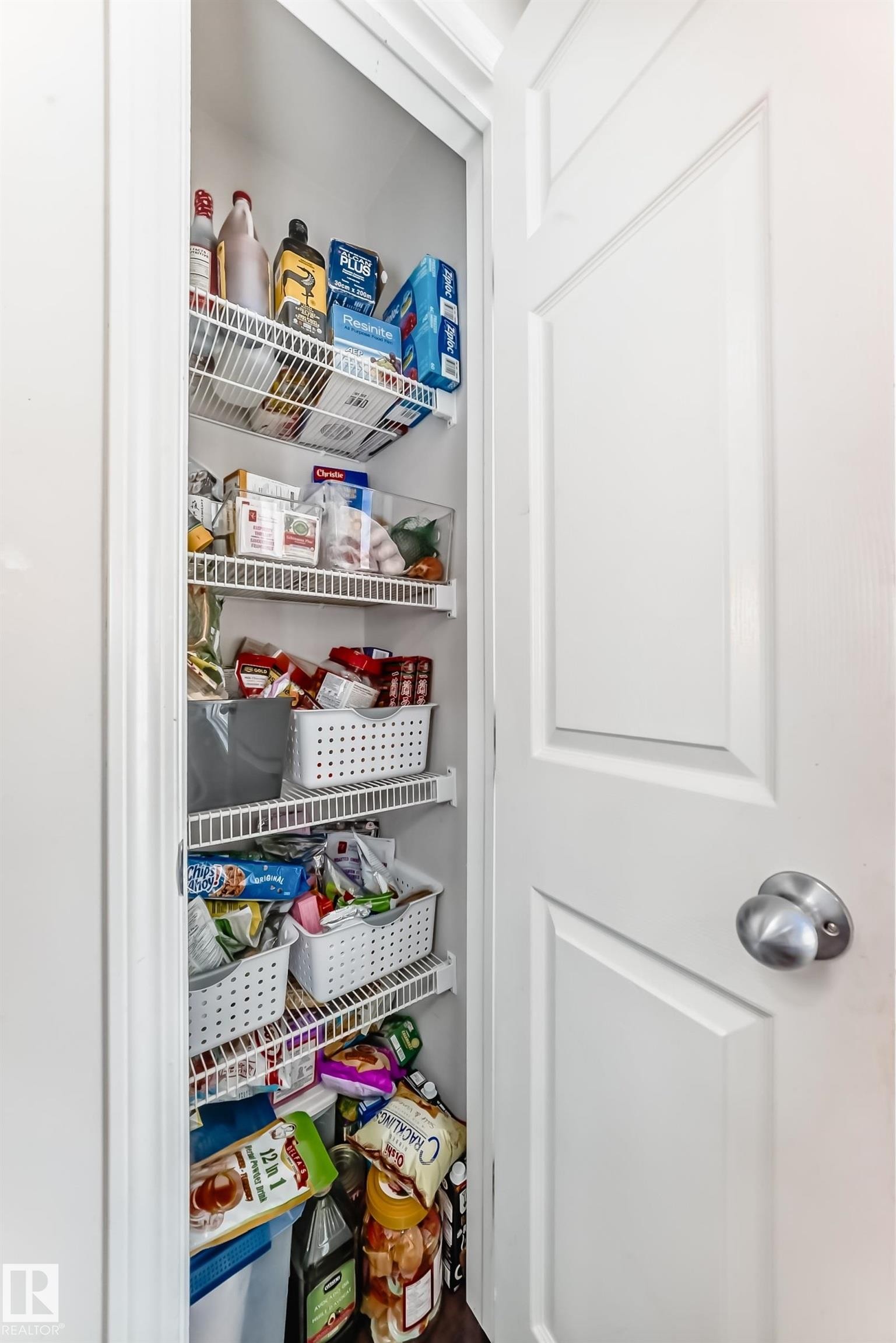 Pantry with wire shelving, a paneled door, and a satin nickel doorknob - 45 4850 Terwillegar Common, Edmonton, AB - Indoor