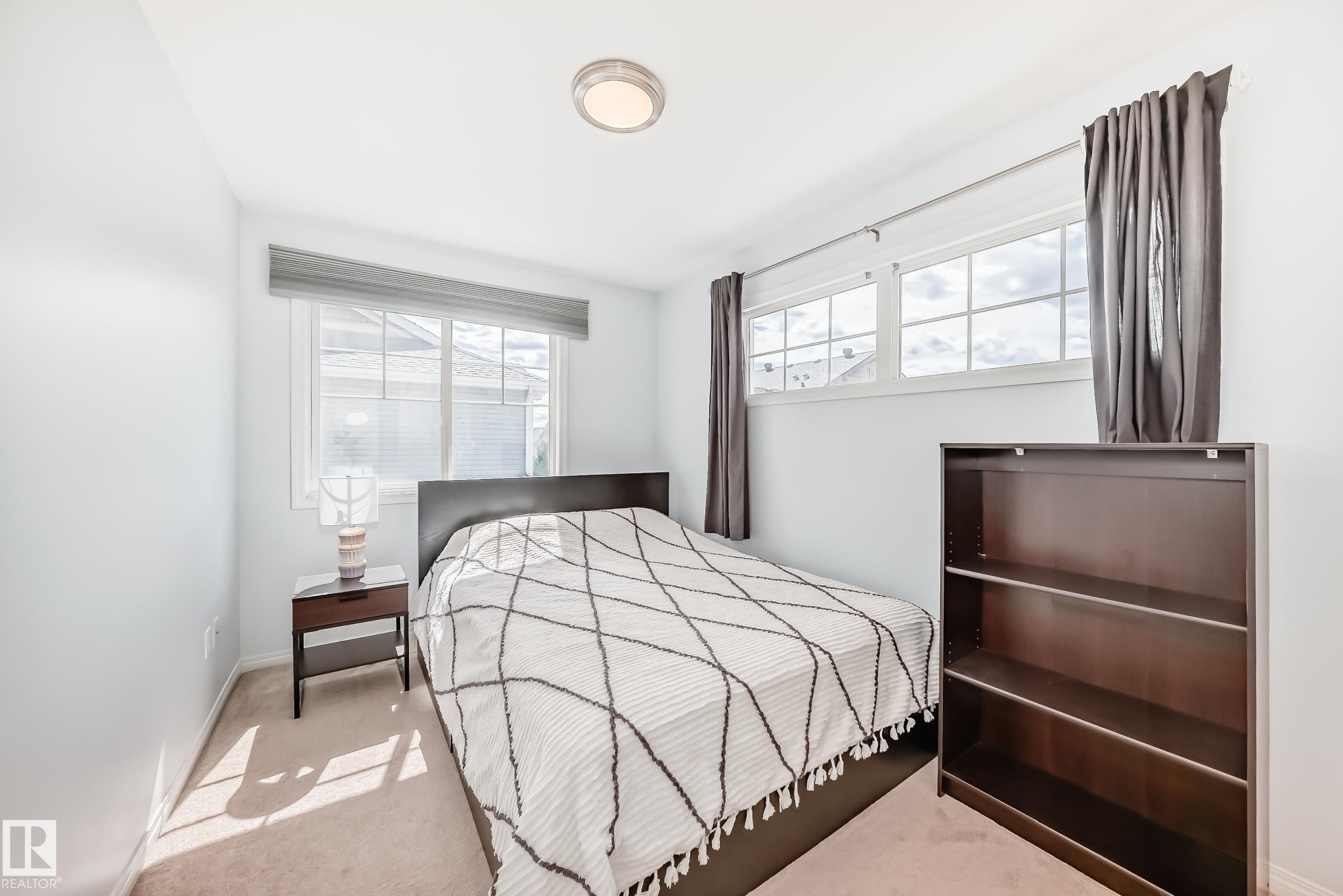 Bedroom with light-colored walls and carpeted flooring - 45 4850 Terwillegar Common, Edmonton, AB - Indoor Photo Showing Bedroom