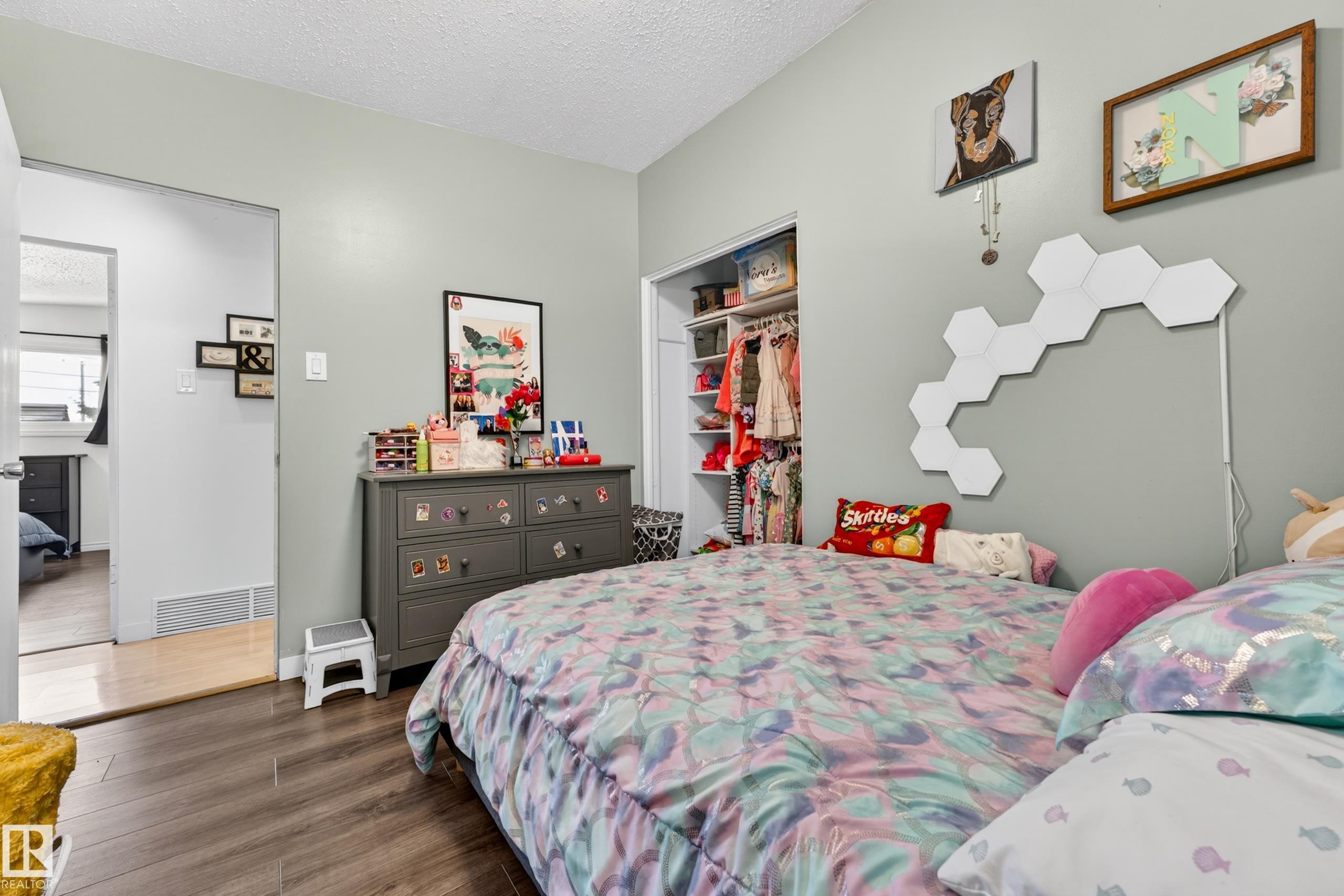 Hardwood-finish flooring, light gray wall paint, and a built-in closet with shelving and hanging rods - 5304 90A Avenue, Edmonton, AB - Indoor Photo Showing Bedroom