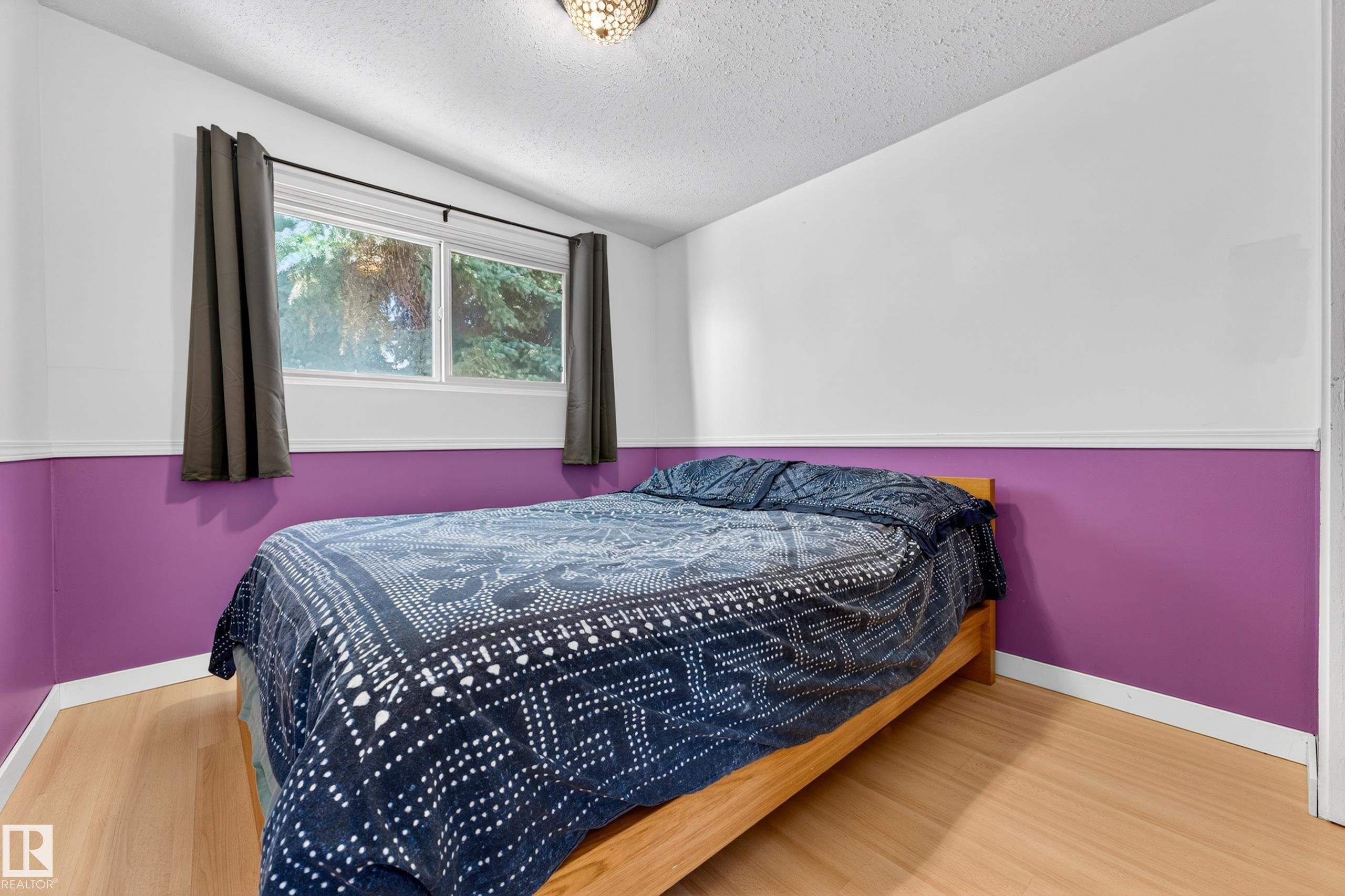 Room with wood-finish flooring, white baseboards, and a two-tone wall treatment - 5304 90A Avenue, Edmonton, AB - Indoor Photo Showing Bedroom
