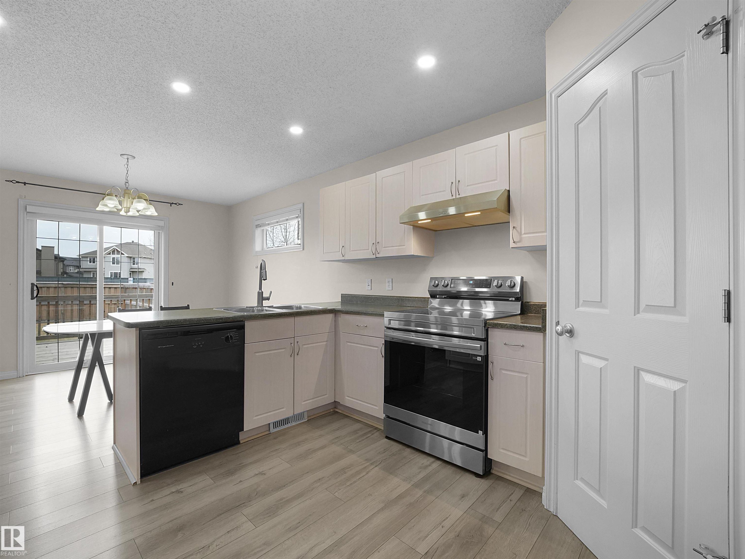 Modern kitchen featuring light-toned cabinetry, stainless steel appliances, and wood-finish flooring - 7407 Singer Landing, Edmonton, AB - Indoor Photo Showing Kitchen