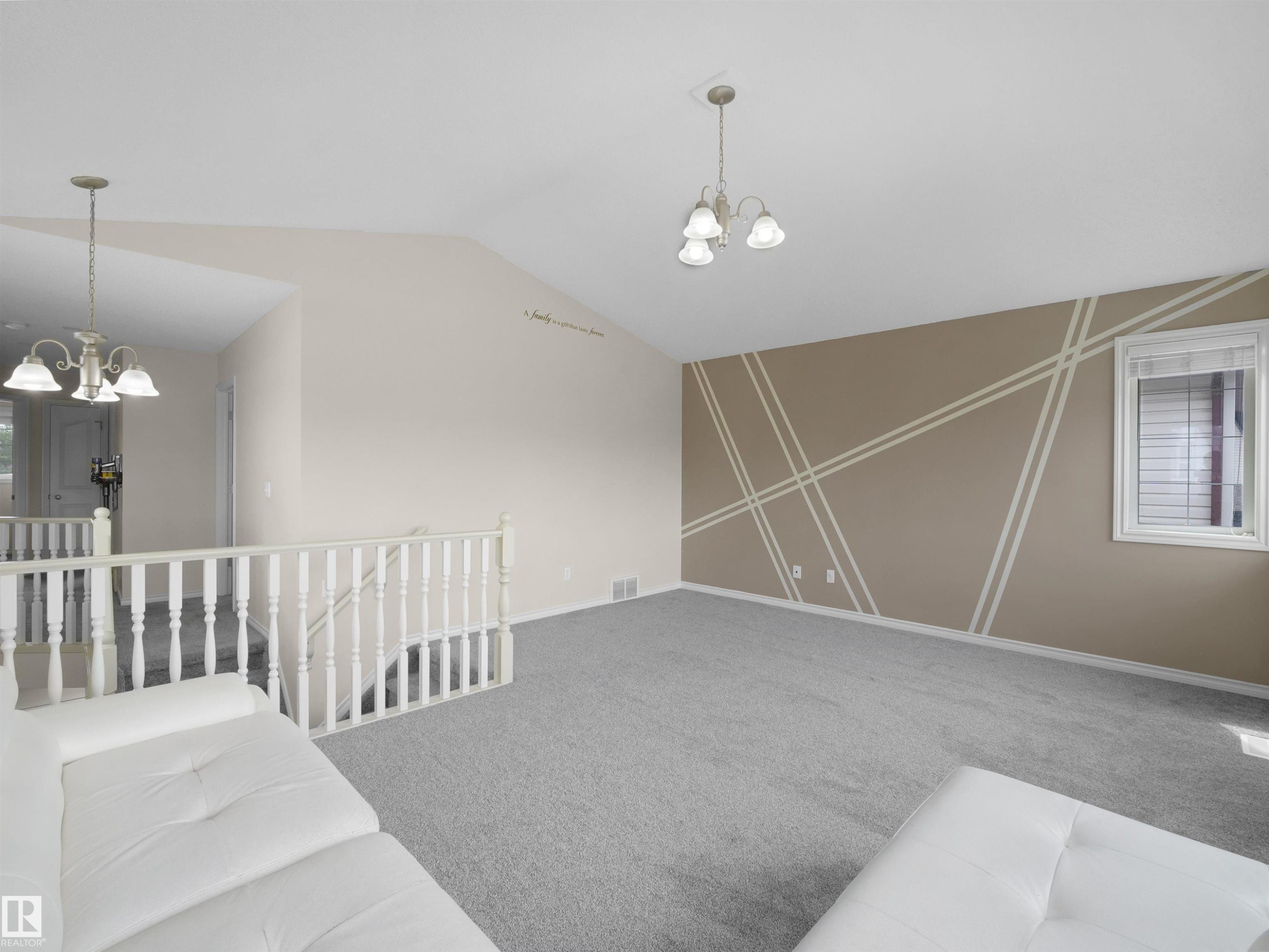 Vaulted ceiling room featuring light gray carpeting, a decorative accent wall, and a window with horizontal blinds - 7407 Singer Landing, Edmonton, AB - Indoor Photo Showing Other Room