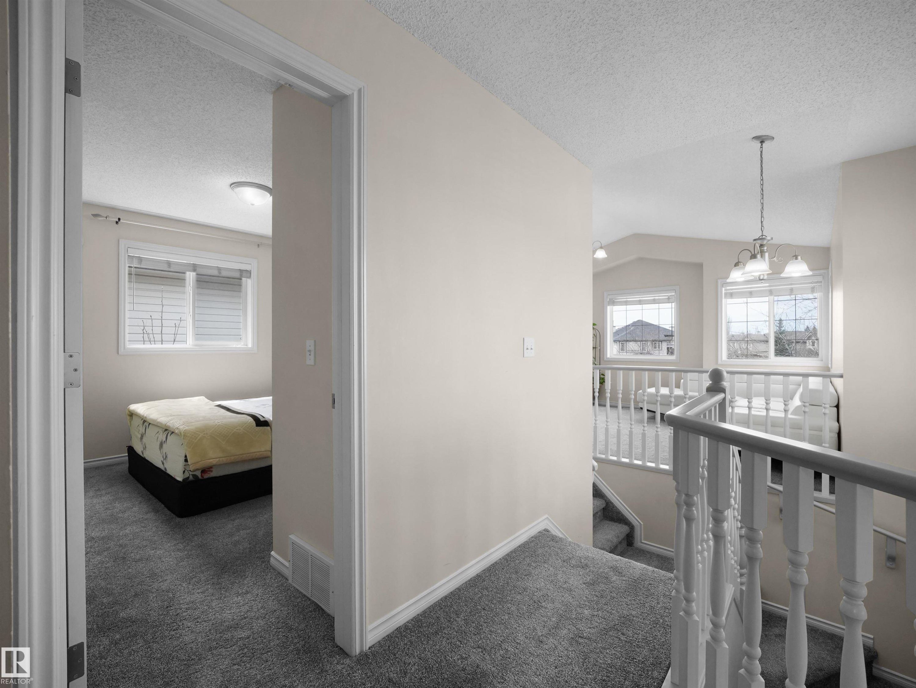 Interior hallway featuring light-toned wall paint and grey carpeting throughout - 7407 Singer Landing, Edmonton, AB - Indoor Photo Showing Other Room