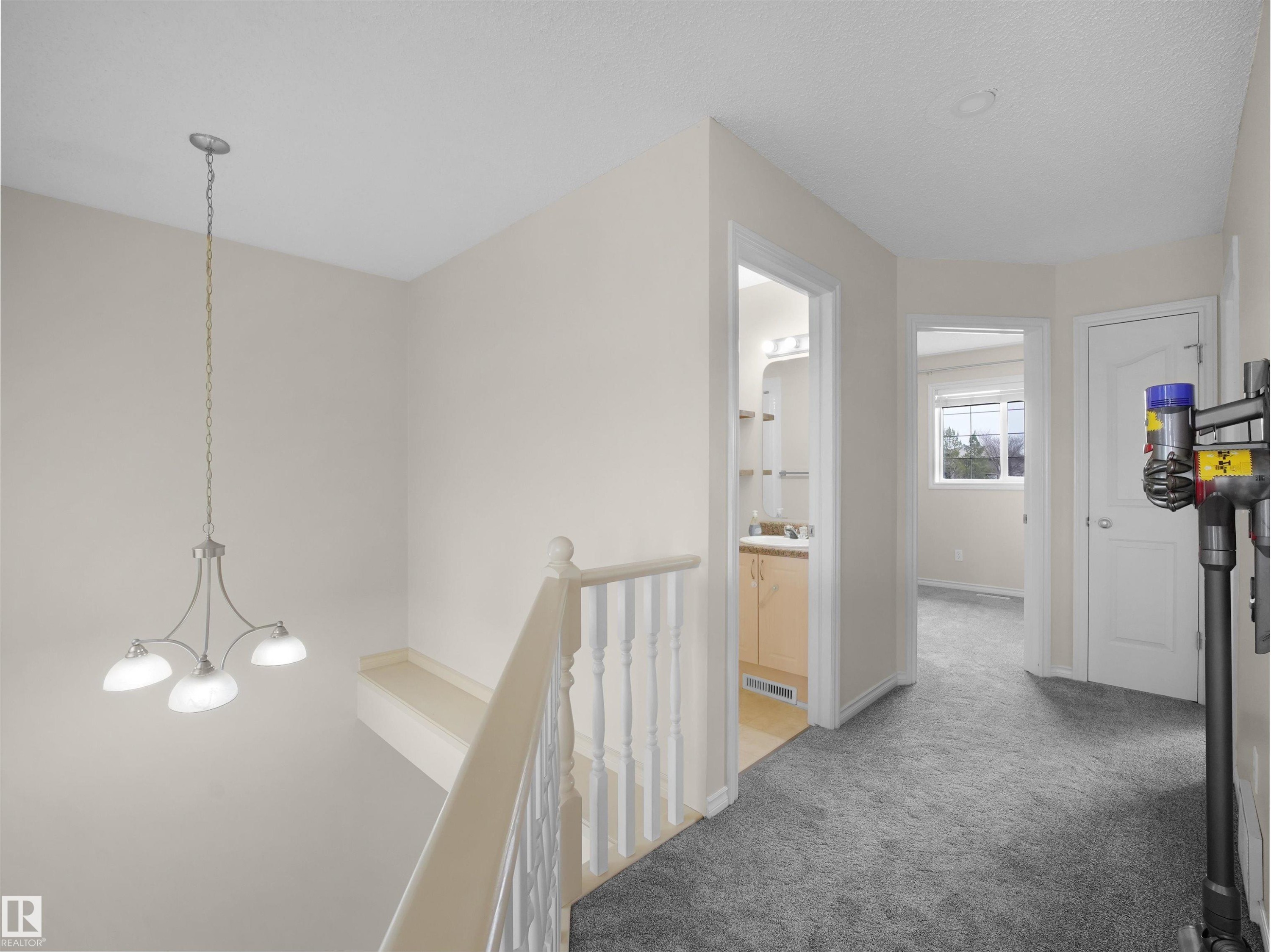 Hallway with light gray carpeting, white trim, and neutral wall tones - 7407 Singer Landing, Edmonton, AB - Indoor Photo Showing Other Room