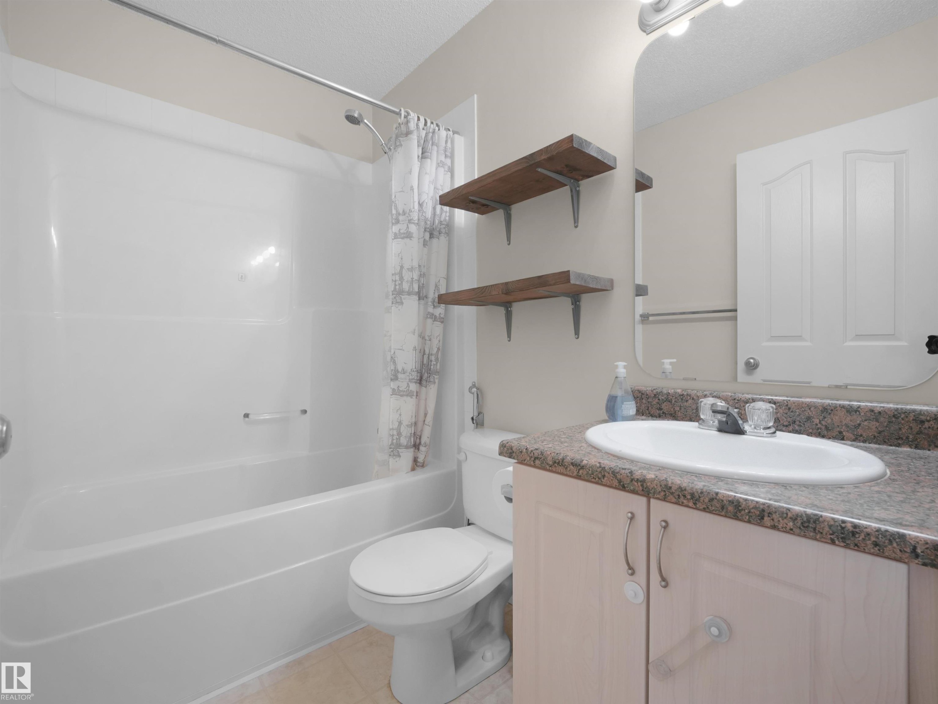 Bathroom featuring a white bathtub, toilet, and vanity with an integrated sink - 7407 Singer Landing, Edmonton, AB - Indoor Photo Showing Bathroom