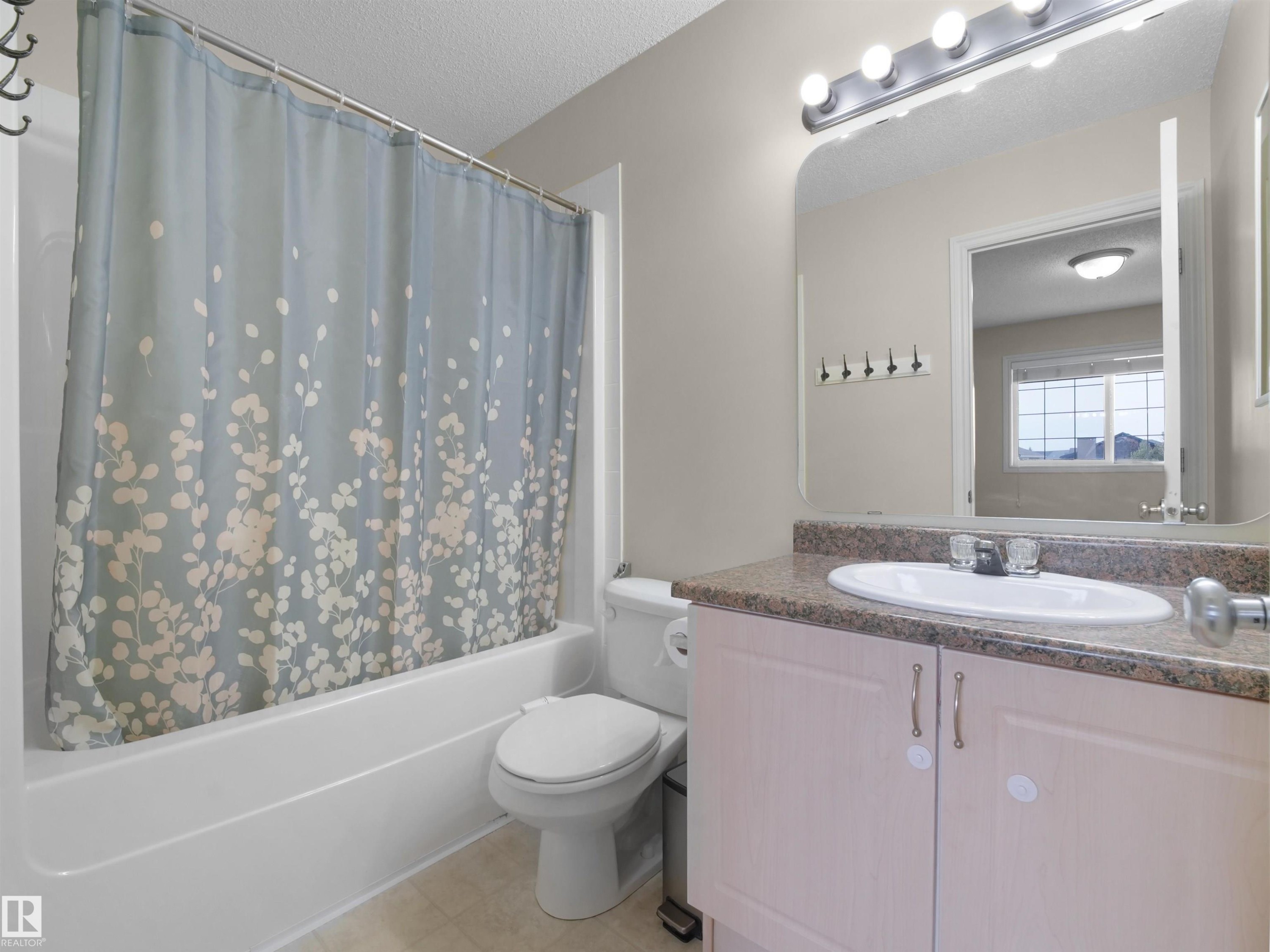 Bathroom featuring a white bathtub, toilet, and a vanity with a surface-mounted sink - 7407 Singer Landing, Edmonton, AB - Indoor Photo Showing Bathroom