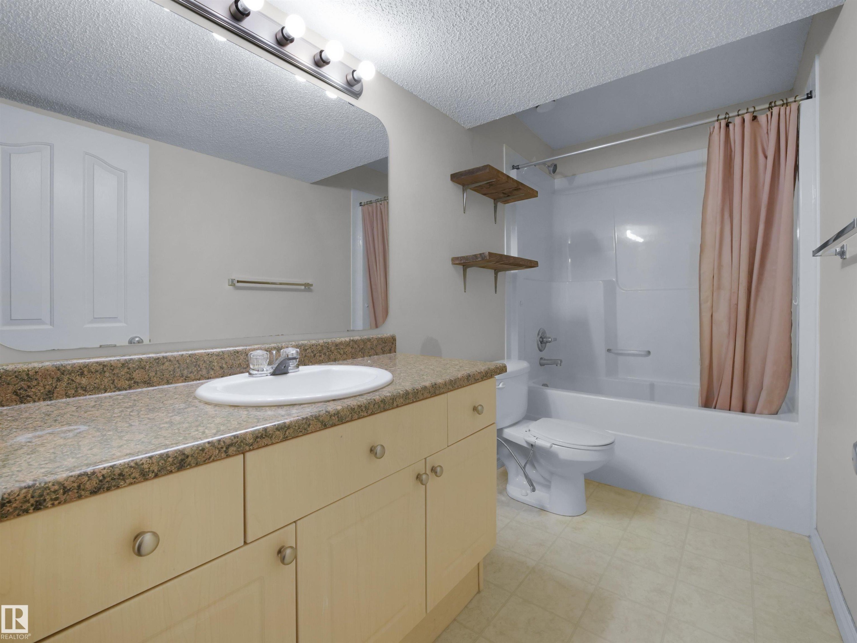 Bathroom featuring a light-toned vanity with stone-look countertop and an integrated sink - 7407 Singer Landing, Edmonton, AB - Indoor Photo Showing Bathroom