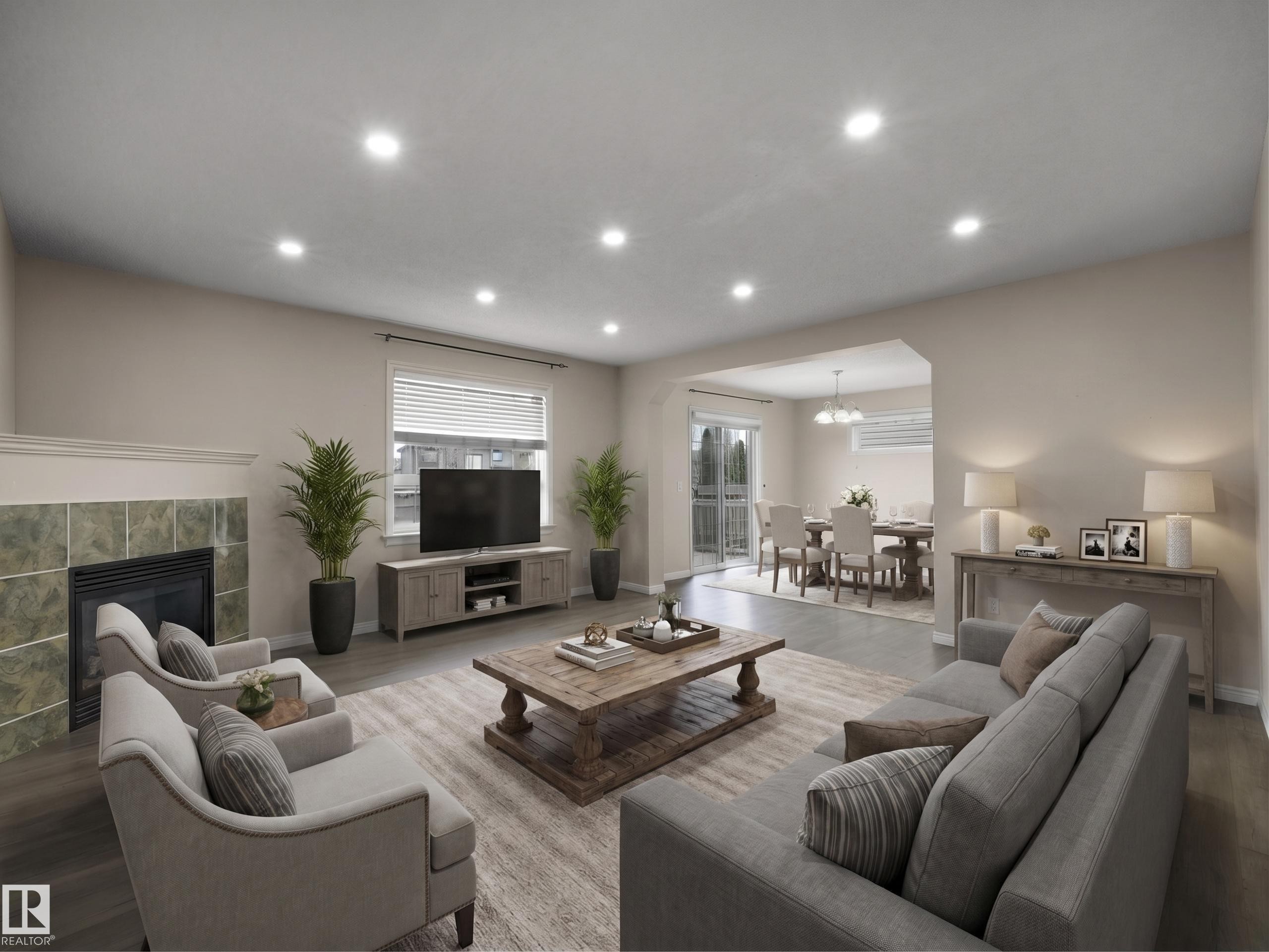 Spacious living area featuring wood-finish flooring, recessed lighting, and a tiled fireplace - 7407 Singer Landing, Edmonton, AB - Indoor Photo Showing Living Room With Fireplace