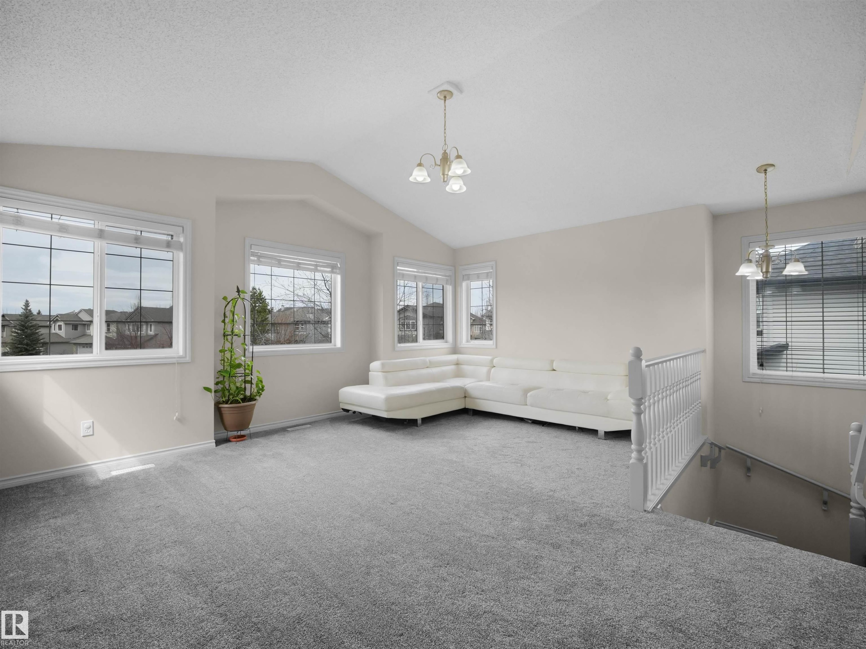 Spacious room with vaulted ceilings and abundant natural light from multiple windows - 7407 Singer Landing, Edmonton, AB - Indoor