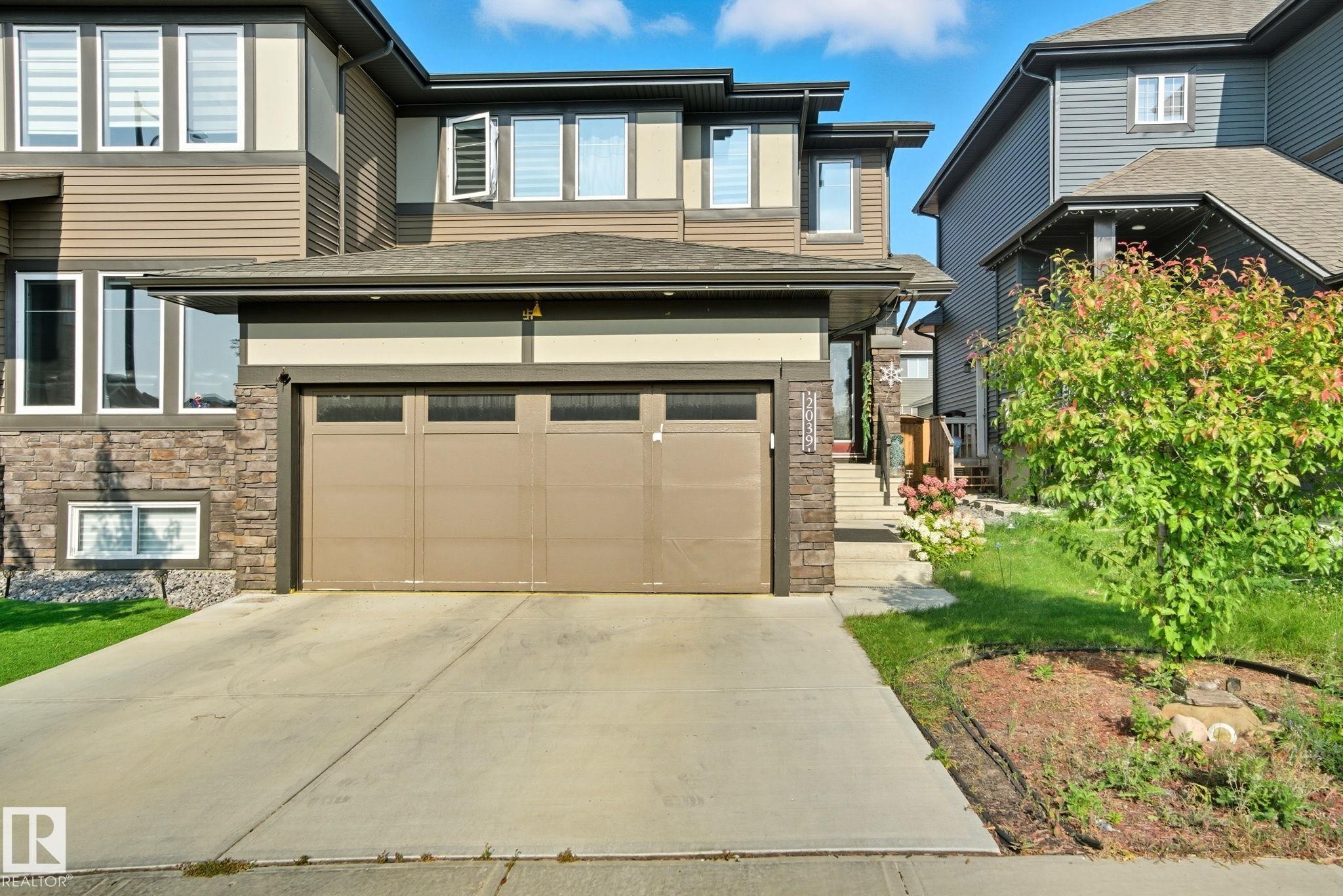 Contemporary two-story exterior with horizontal siding and stone accents - 2039 Wonnacott Way, Edmonton, AB