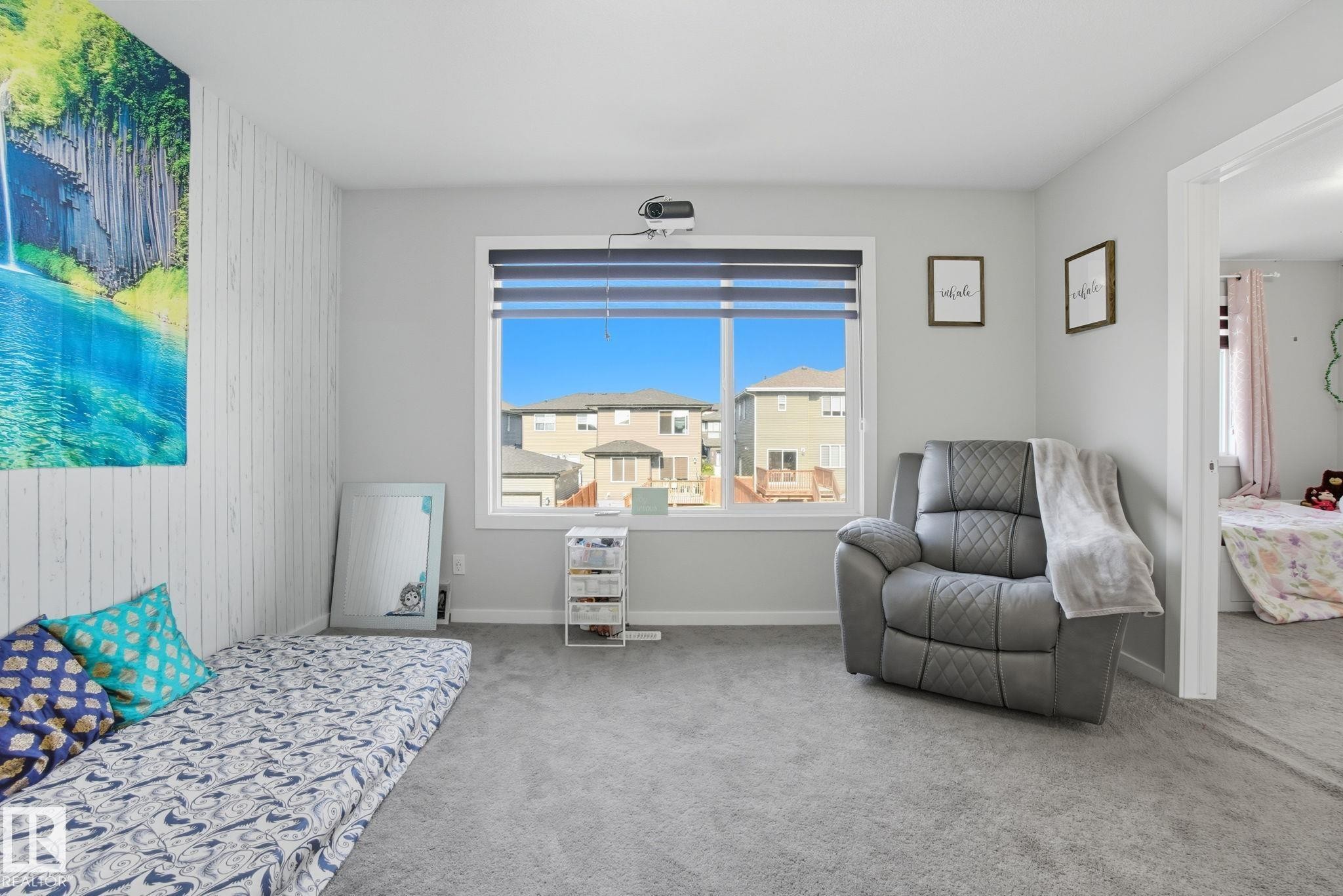 Bright room featuring a large window with horizontal blinds, light gray wall paint, and gray carpet flooring - 2039 Wonnacott Way, Edmonton, AB