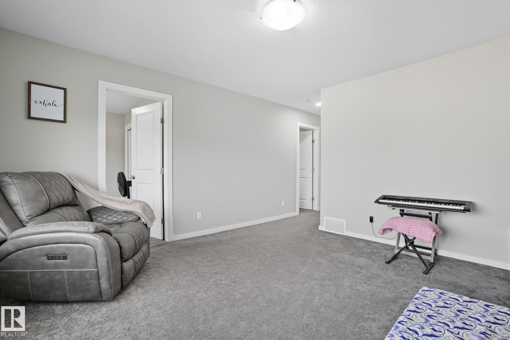 Carpeted interior space featuring light gray wall paint and white trim - 2039 Wonnacott Way, Edmonton, AB