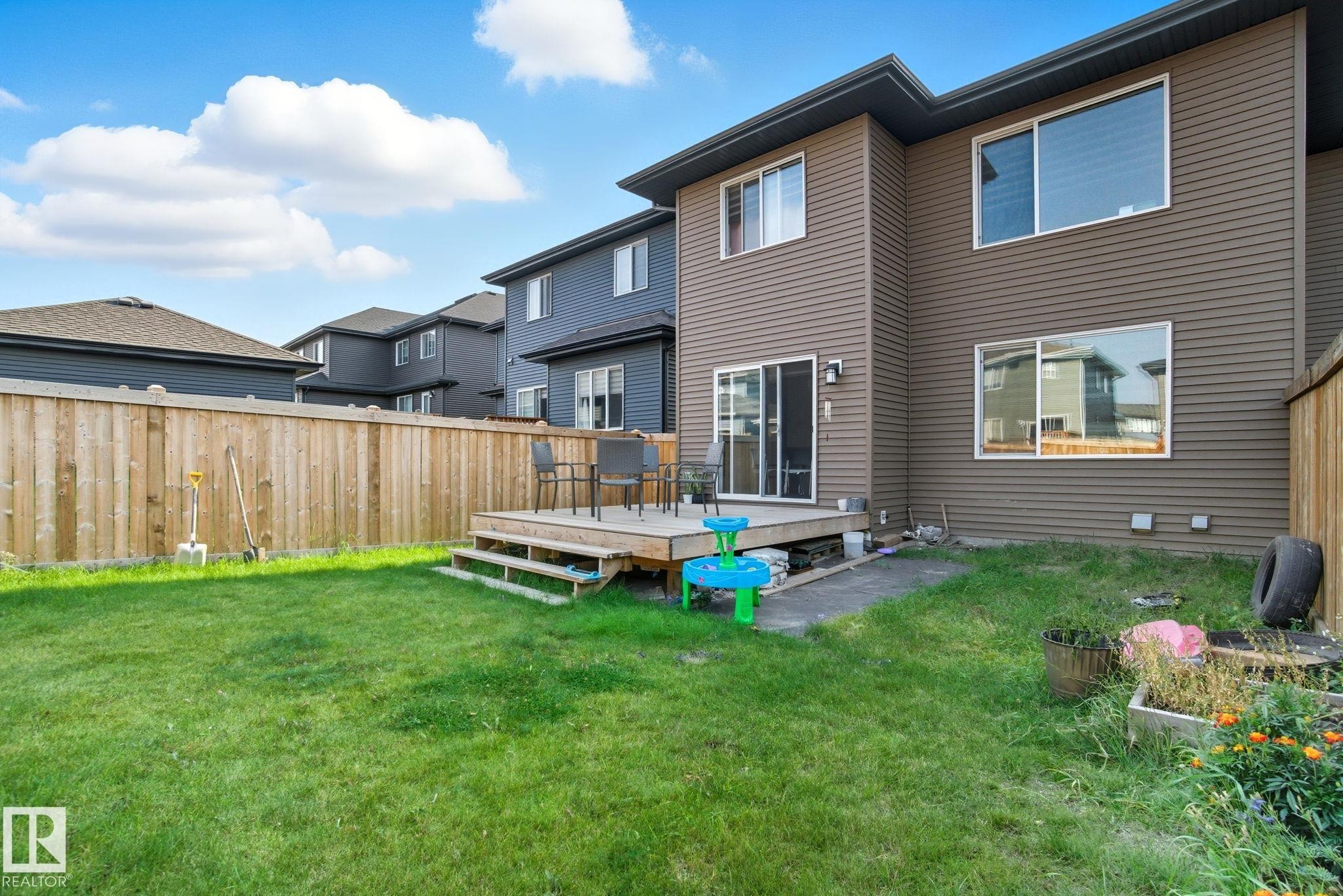 Expansive green lawn with a wooden privacy fence - 2039 Wonnacott Way, Edmonton, AB