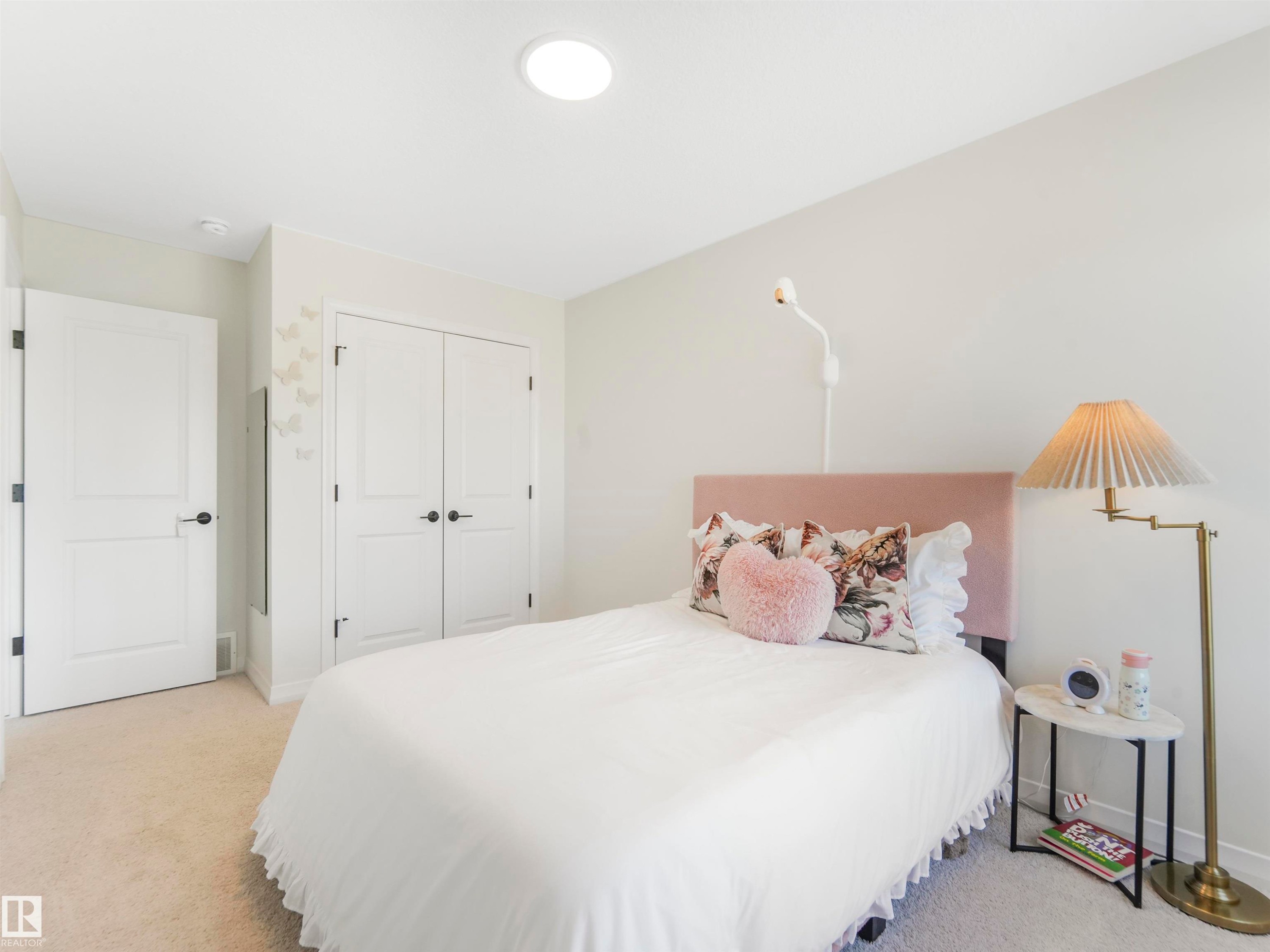 This bedroom features light-colored carpeting, a ceiling light fixture, and white walls - 19 Nettle Crescent, St. Albert, AB - Indoor Photo Showing Bedroom