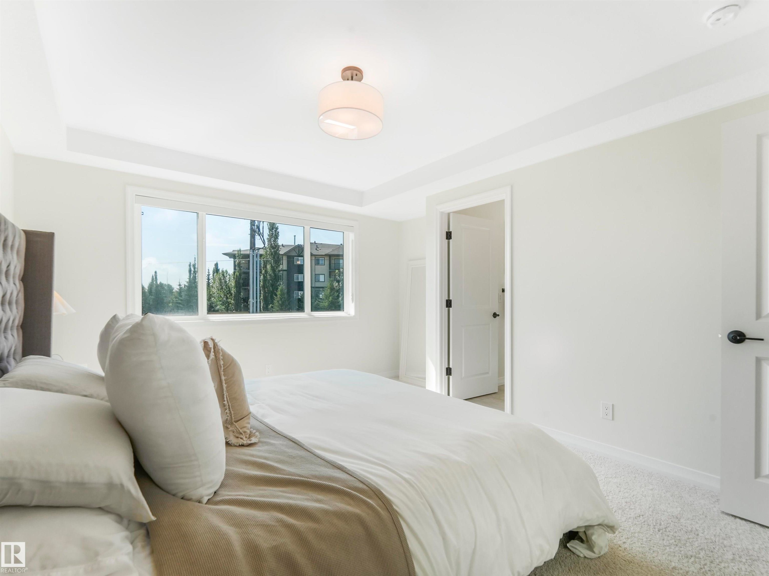 The property features a bright room with a large window, white walls, and a ceiling light fixture - 19 Nettle Crescent, St. Albert, AB - Indoor Photo Showing Bedroom