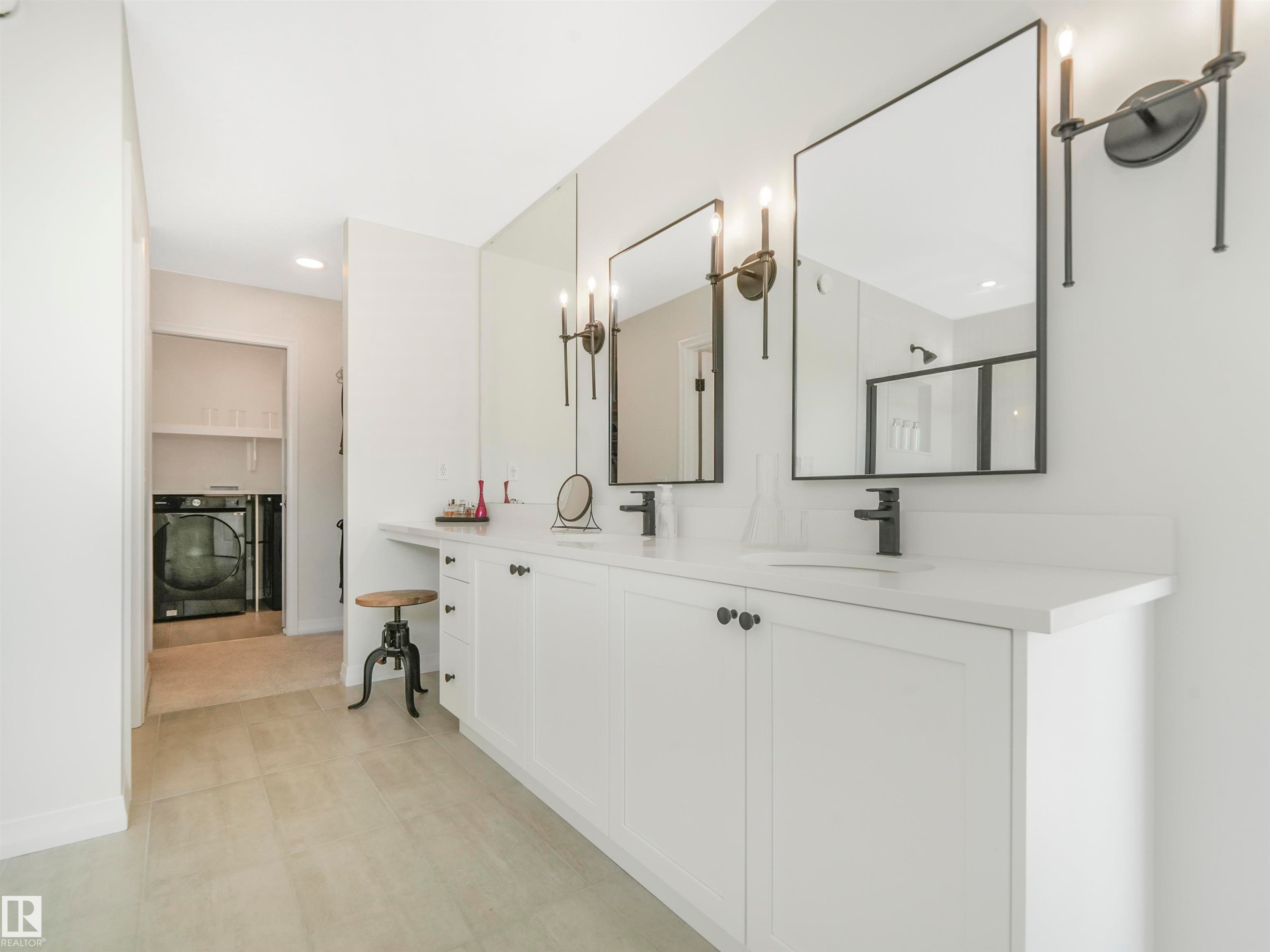 This bathroom features a double vanity with white cabinetry, a light-colored countertop, and two mirrors with black frames - 19 Nettle Crescent, St. Albert, AB - Indoor
