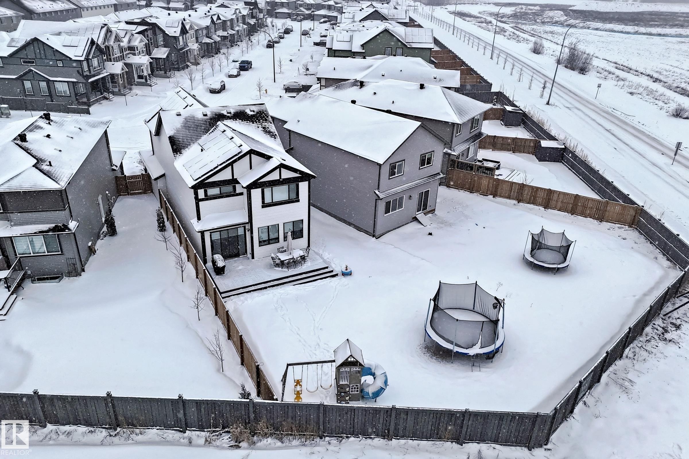 The property features a two-story exterior with dark trim detailing, a rear deck, and a fenced backyard - 19 Nettle Crescent, St. Albert, AB - Outdoor