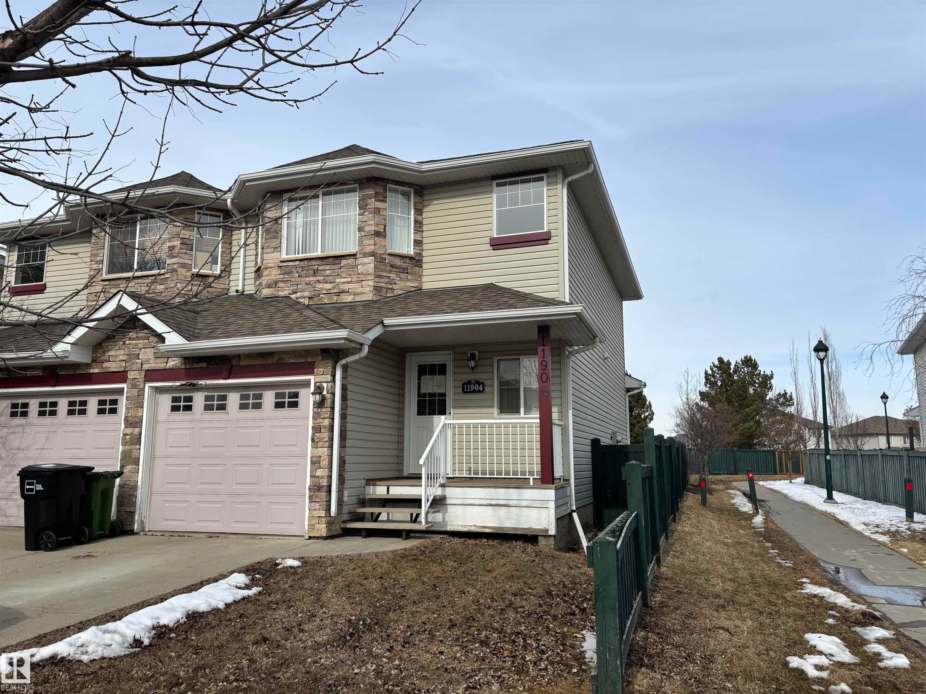 The property features a two-story exterior with light-colored siding and stone accents - 11904 18 Avenue, Edmonton, AB - Outdoor