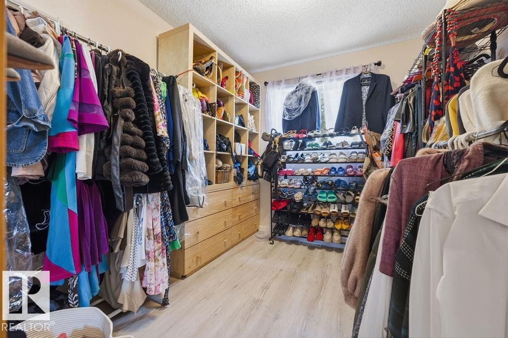 Custom closet system featuring wood-finish cabinetry and drawers - 7422 188 Street, Edmonton, AB