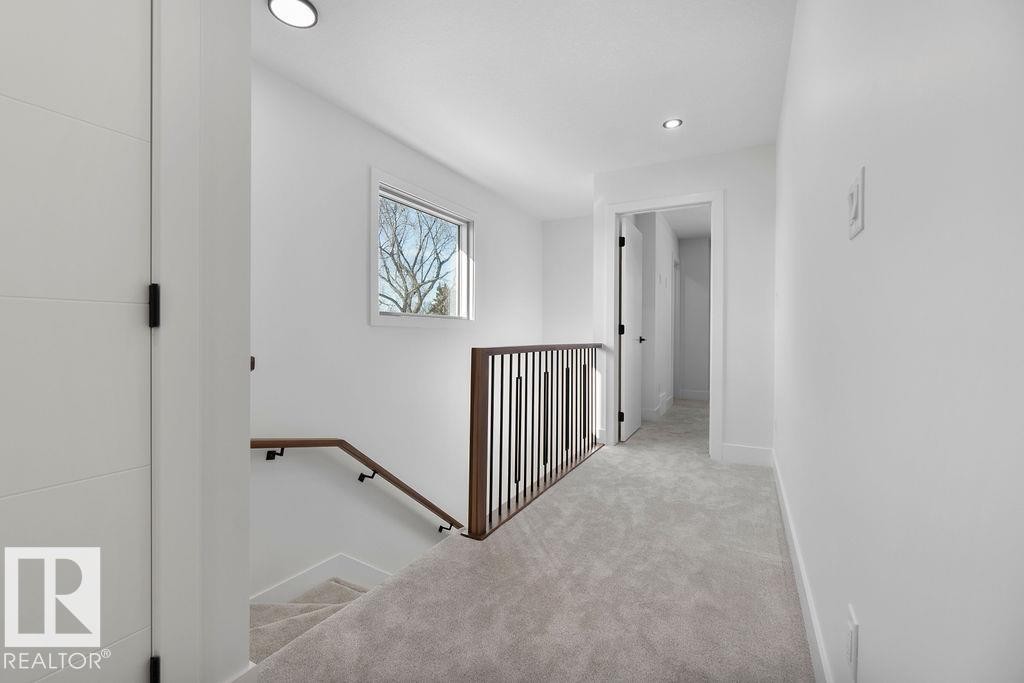 The upper level features carpeted flooring, a window providing natural light, and recessed lighting - 12307 91 St Nw, Edmonton, AB - Indoor Photo Showing Other Room