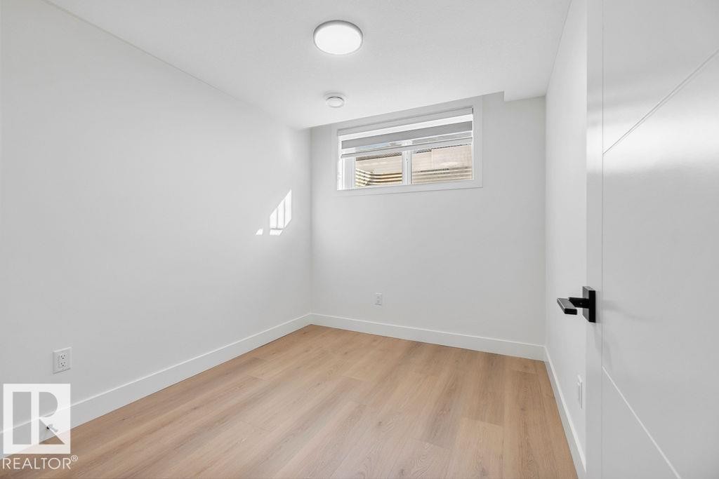 This room features light-toned hardwood flooring and a neutral color palette - 12307 91 St Nw, Edmonton, AB - Indoor Photo Showing Other Room